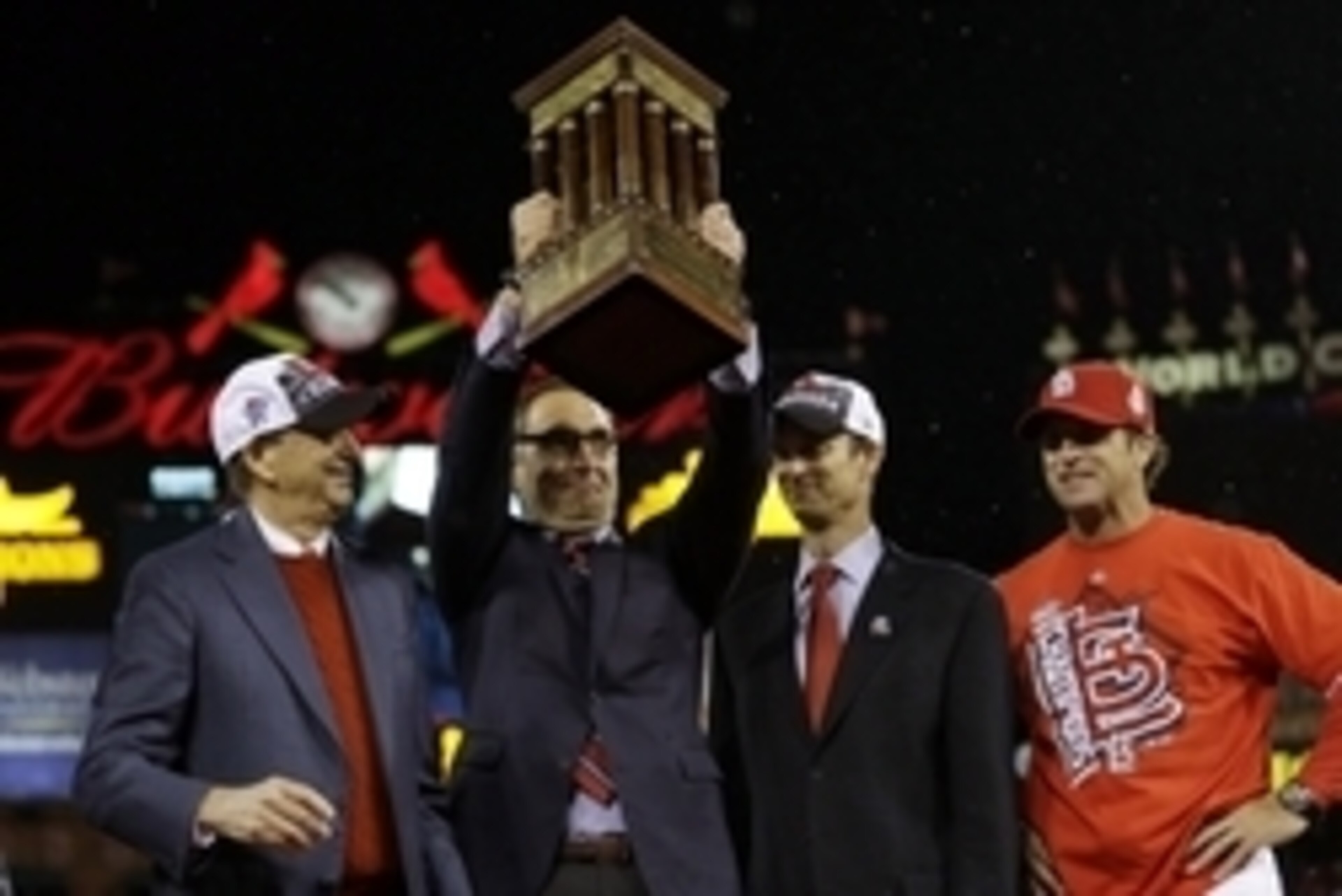 Cardinals' GM John Mozeliak hoists the Warren C. Giles trophy after winning the NL pennant in 2013.