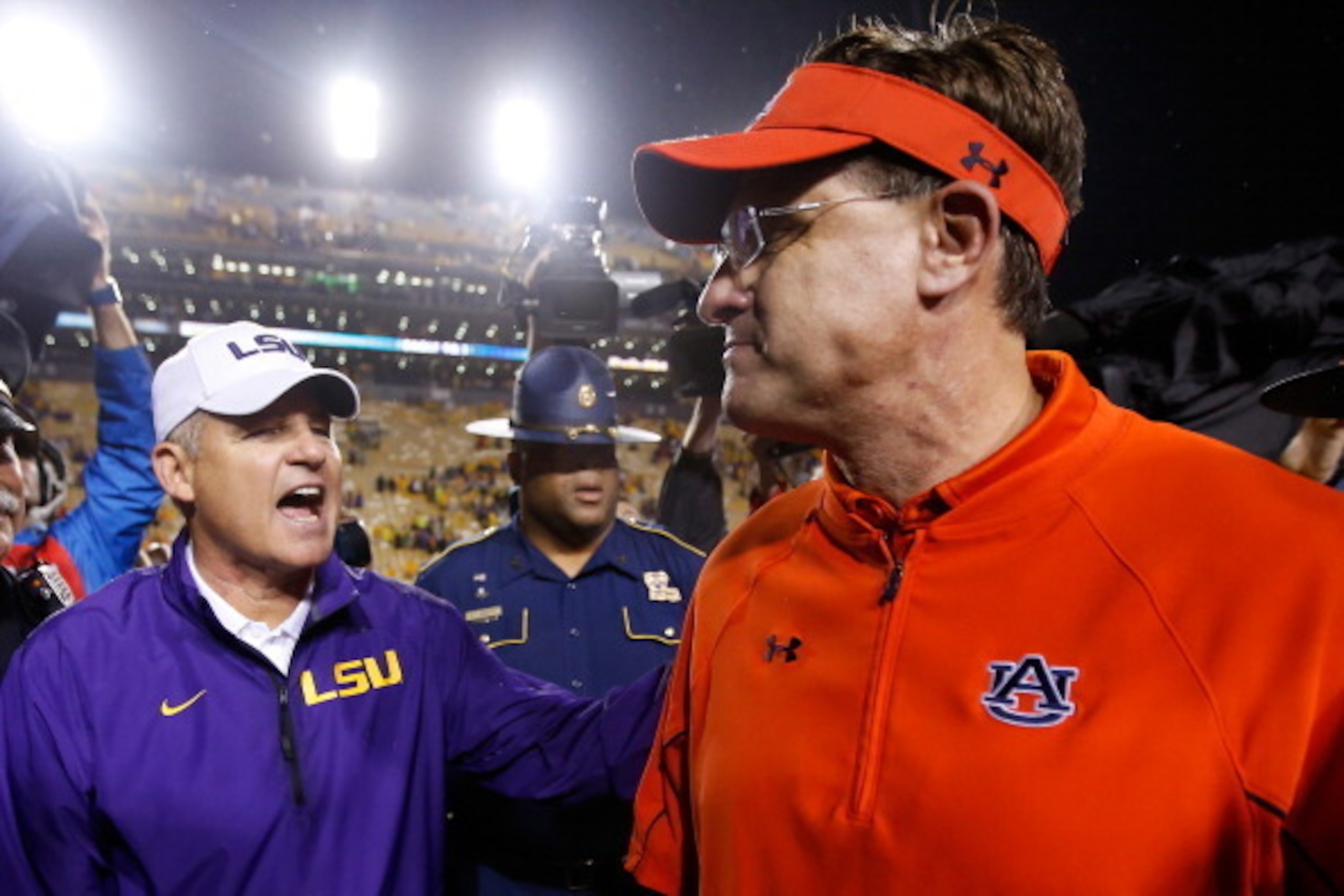 Auburn head coach Gus Malzahn (right) will look to get avenge his only conference loss in 2013 against LSU head coach Les Miles (right) this season.