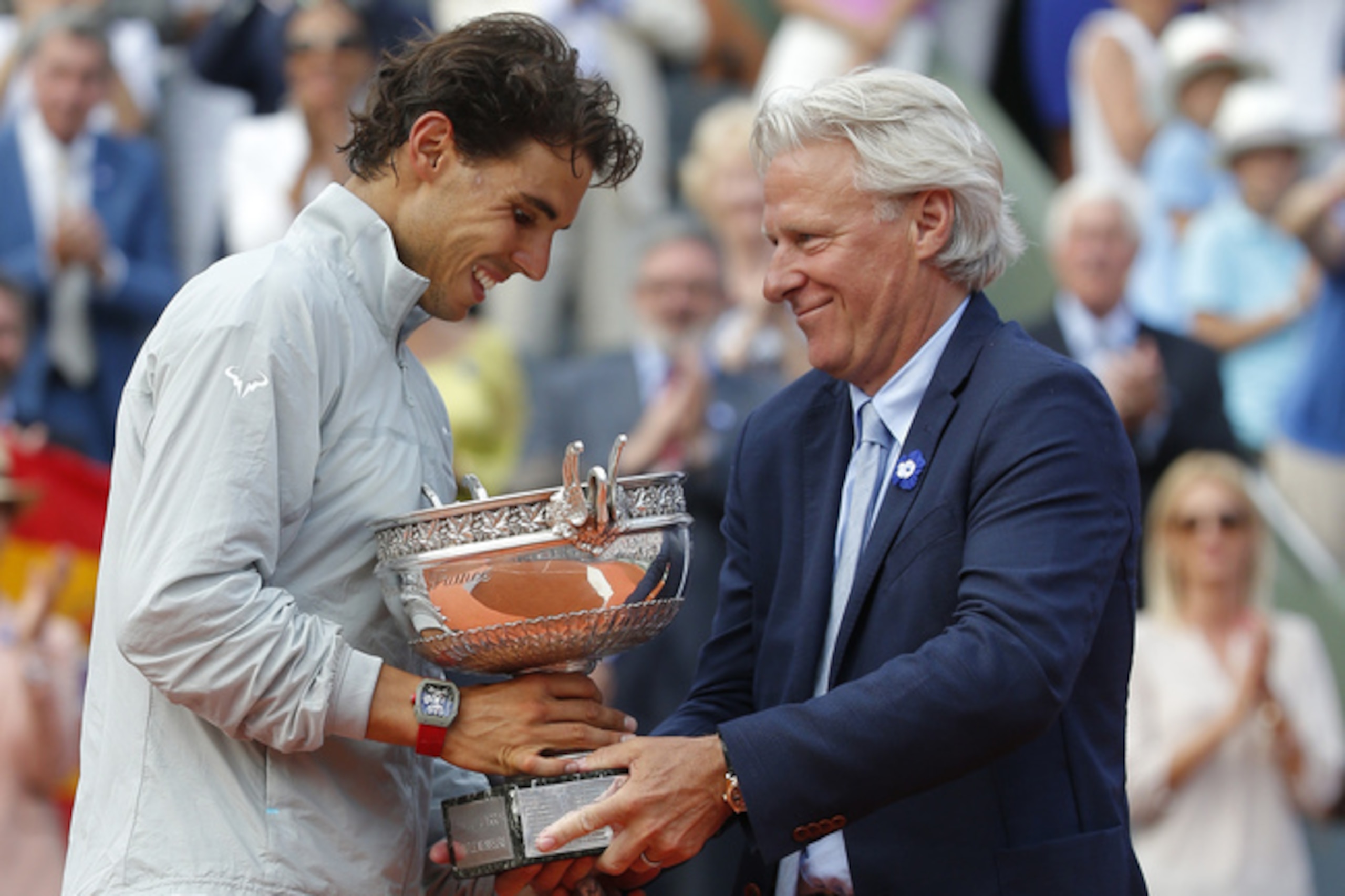 Bjorn Borg, who won six French Open titles, hands the winner's trophy to Rafael Nadal, who won his ninth.
