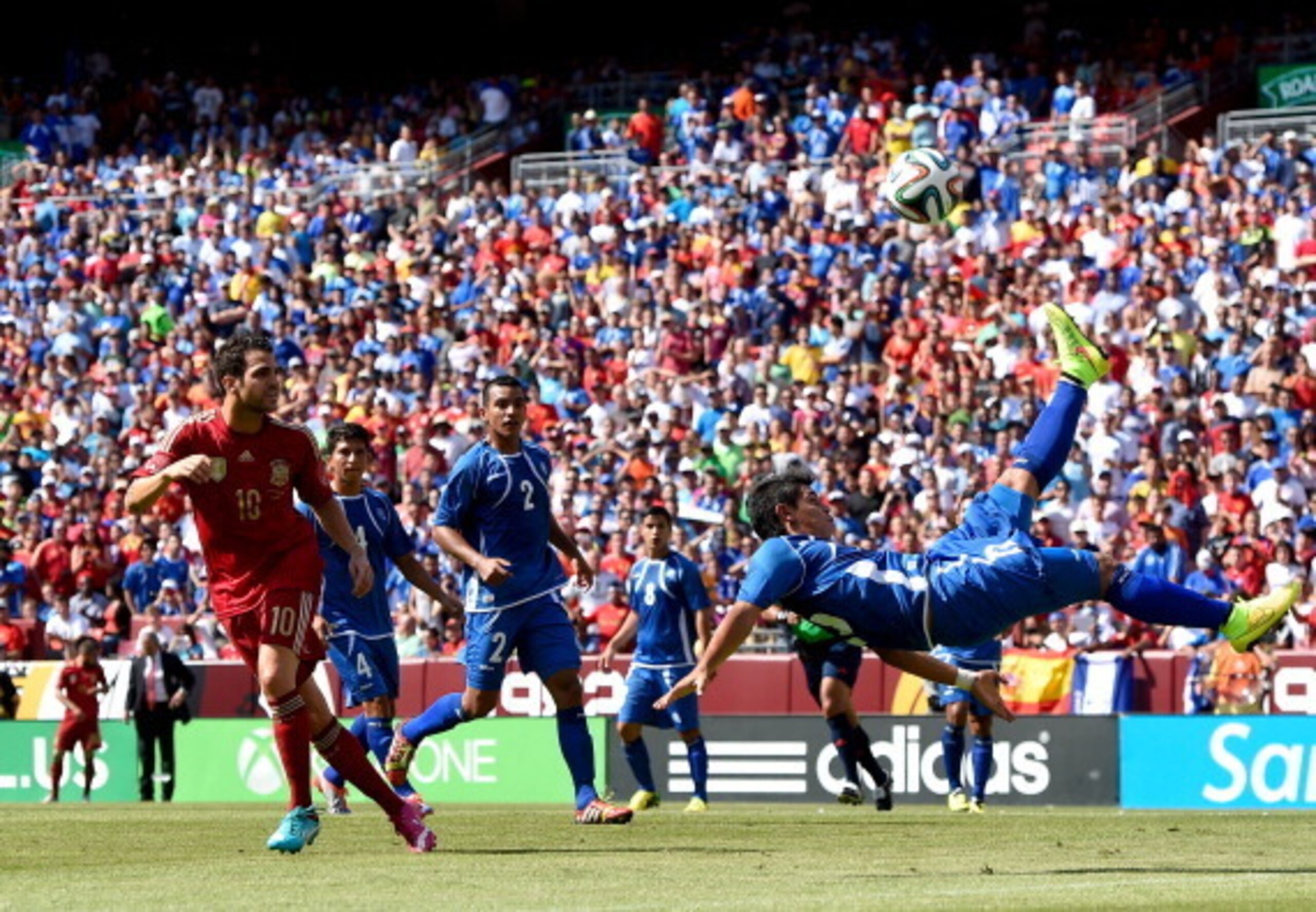 LANDOVER, MD - JUNE 07:  Raul Renderos of El Salvador does an overhead next to Cesc Fabregas of Spain during an international friendly match between El Salvador and Spain at FedExField on June 7, 2014 in Landover, Maryland.  (Photo by David Ramos/Getty Im