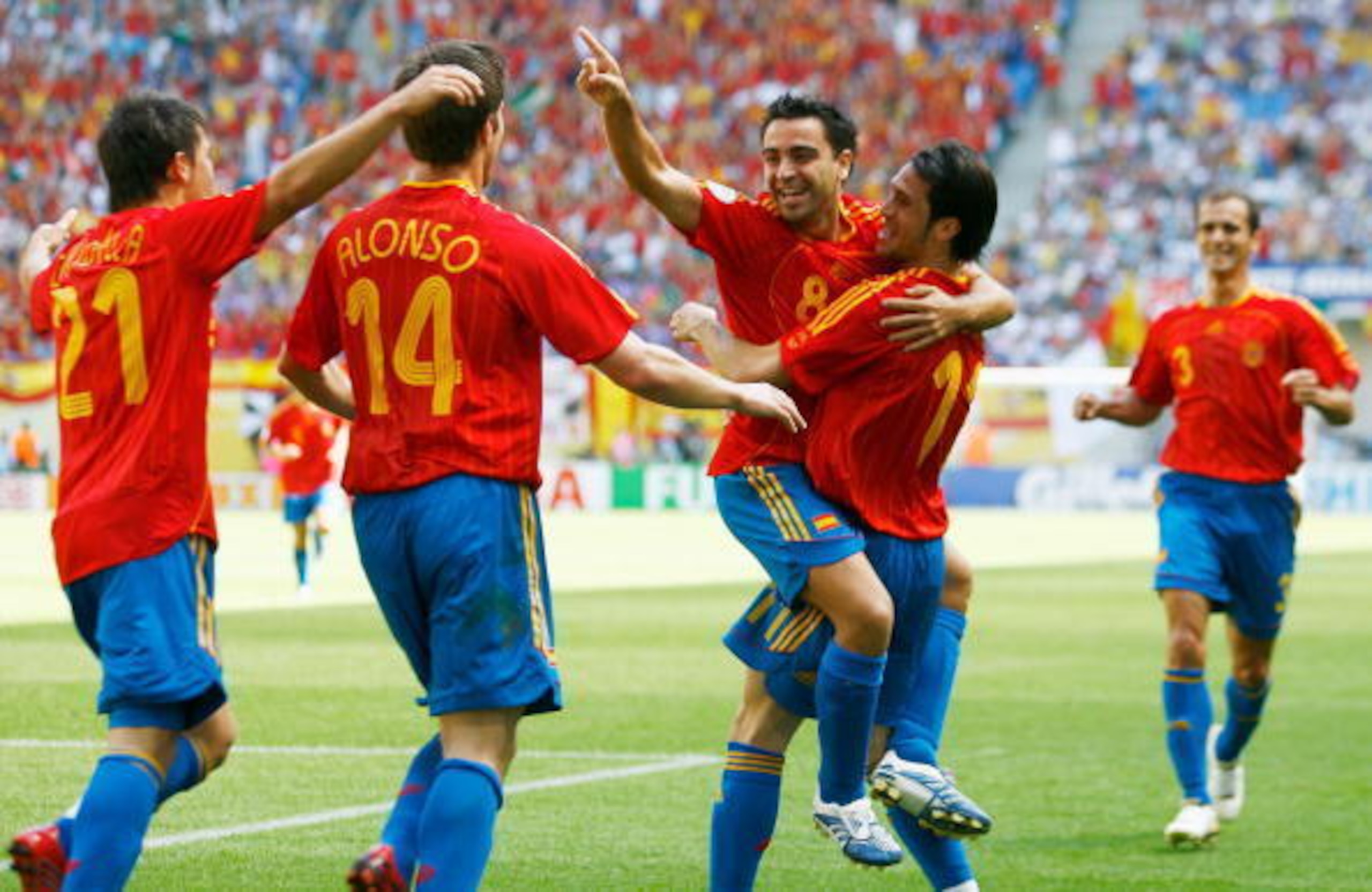 Xavi (centre, No 8) celebrates against Ukraine.