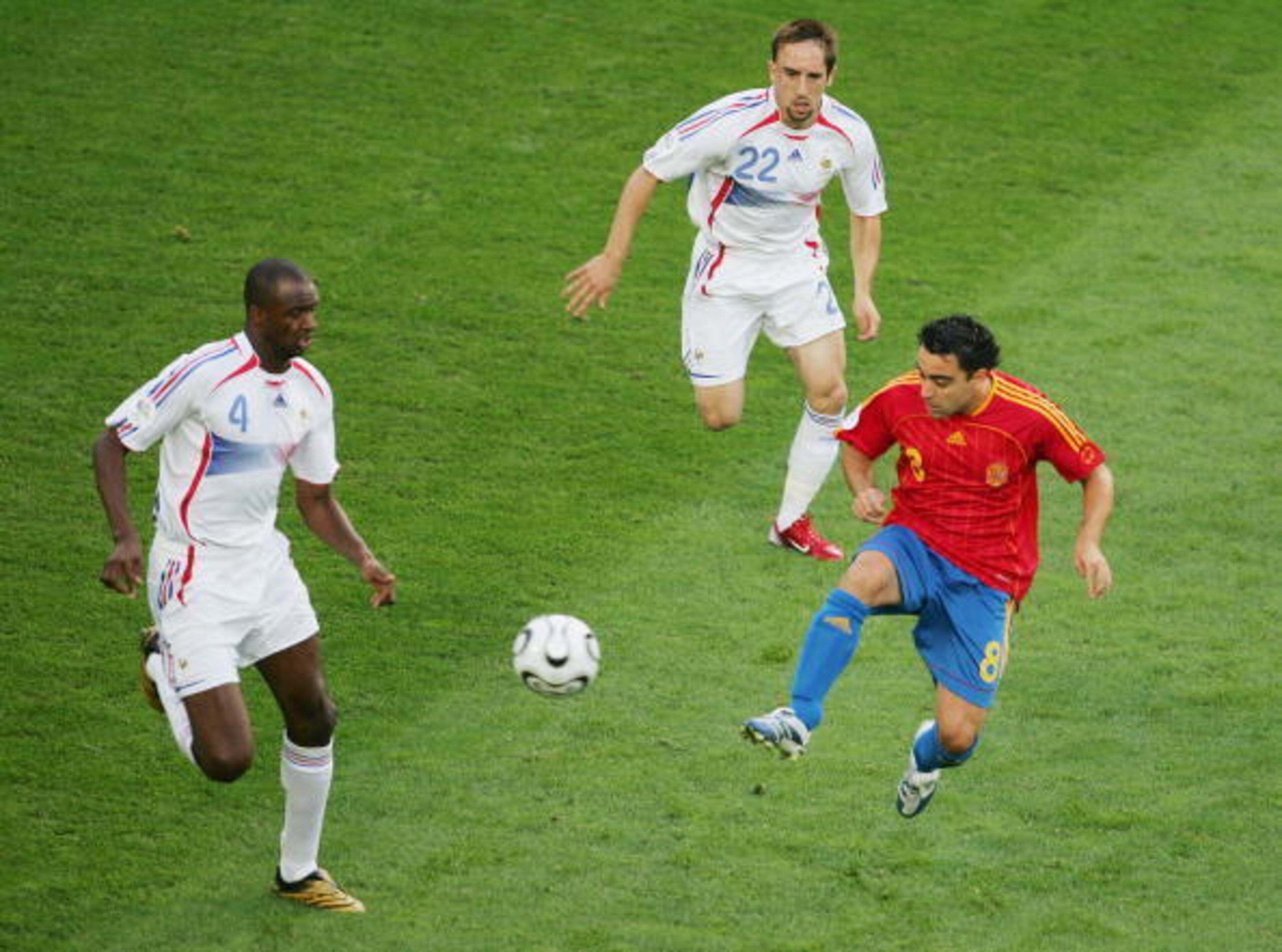 HANOVER, GERMANY - JUNE 27: Xavi of Spain attempts to win the ball under pressure from Patrick Vieira and Frank Ribery of France during the FIFA World Cup Germany 2006 Round of 16 match between Spain and France played at the Stadium Hanover on June 27, 20