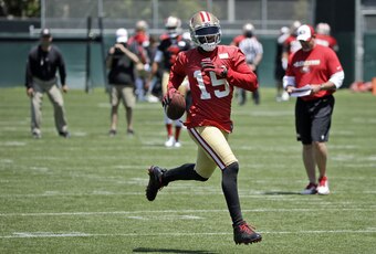 The 49ers head coach Jim Harbaugh watches intently in the background at star wideout Michael Crabtree during a May OTA.