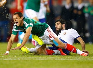 FOXBORO, MA - JUNE 06:  Javier Hernandez #14 of Mexico is fouled by Neto #14 of Portugal in the second half during the international friendly match at Gillette Stadium on June 6, 2014 in Foxboro, Massachusetts.  (Photo by Jared Wickerham/Getty Images)