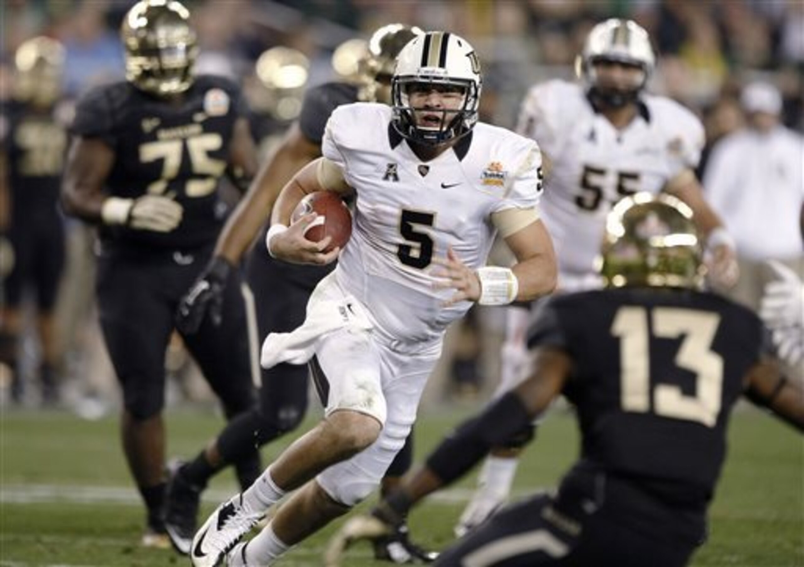 Central Florida quarterback Blake Bortles (5) dashes for a rushing touchdown as Baylor safety Terrell Burt (13) defends during the second half of the Fiesta Bowl NCAA college football game, Wednesday, Jan. 1, 2014, in Glendale, Ariz. (AP Photo/Rick Scuter