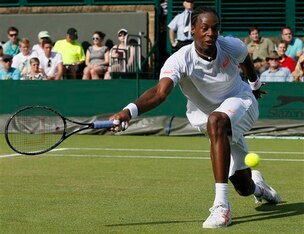 Gael Monfils stretches to make a play during a Wimbledon match.