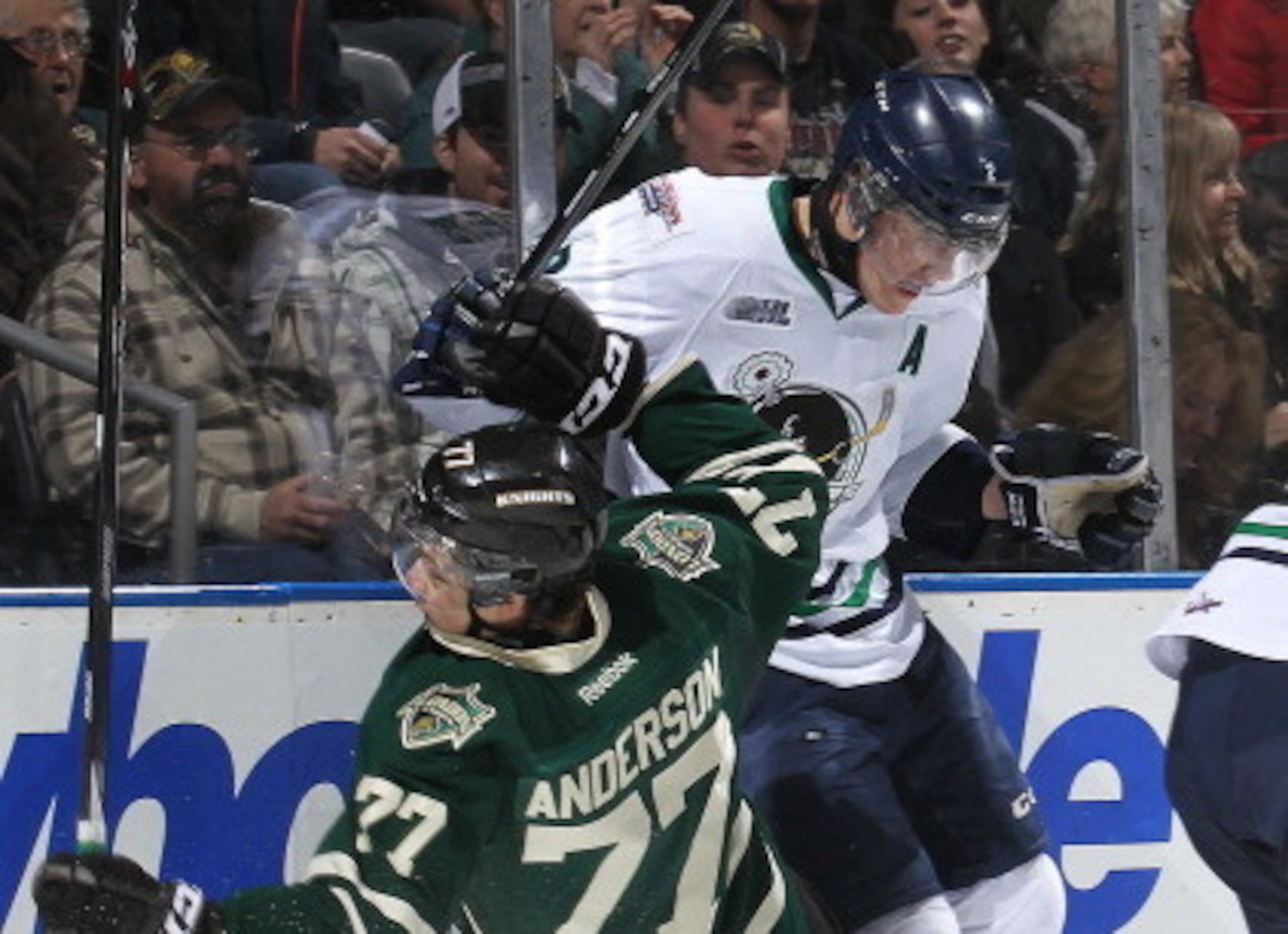 Peters (in white) delivers a crushing hit during the 2013-14 OHL season for Plymouth.