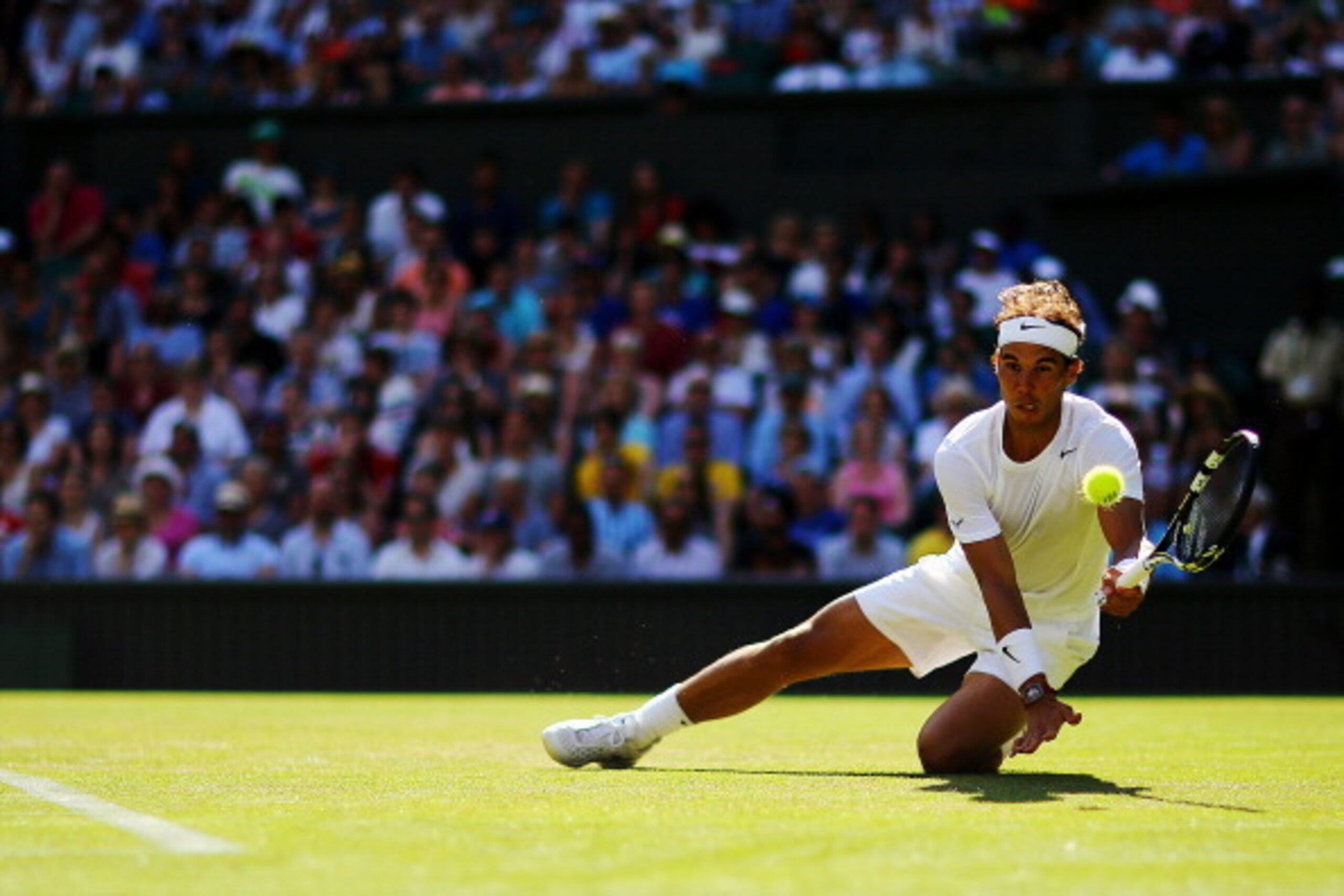 Rafael Nadal gets real low to make a play on the ball during his first-round match at Wimbledon, 2014.