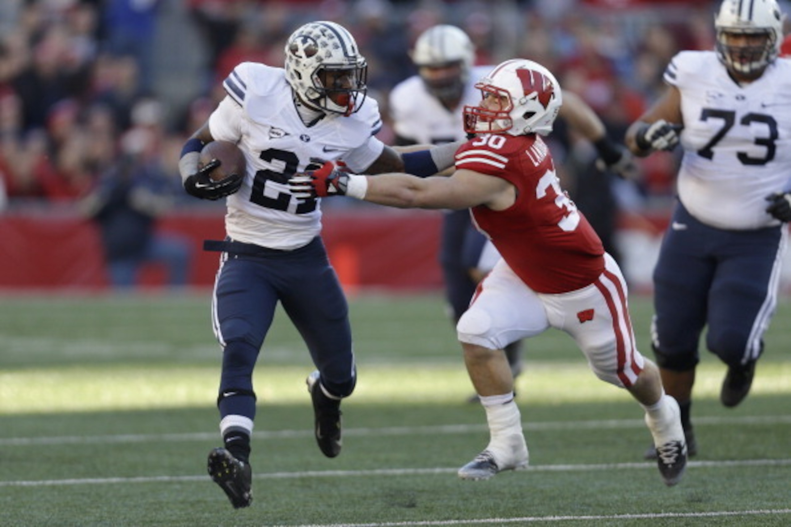 MADISON, WI - NOVEMBER 09: Jamaal Williams #21 of the BYU Cougars runs with the football before getting tackled by Derek Landisch #30 of the Wisconsin Badgers during the game at Camp Randall Stadium on November 09, 2013 in Madison, Wisconsin. (Photo by Mi