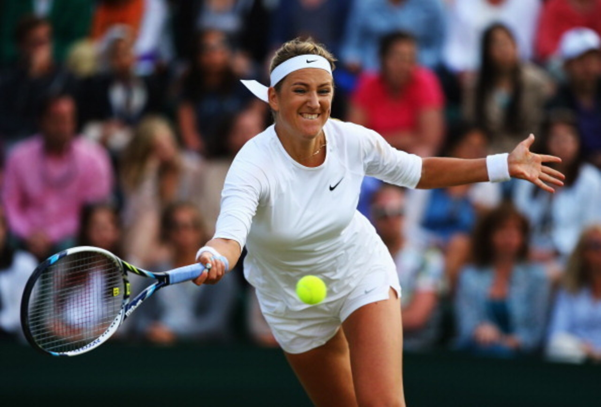 Victoria Azarenka reaches for the ball during a match in the early rounds of 2014 Wimbledon.