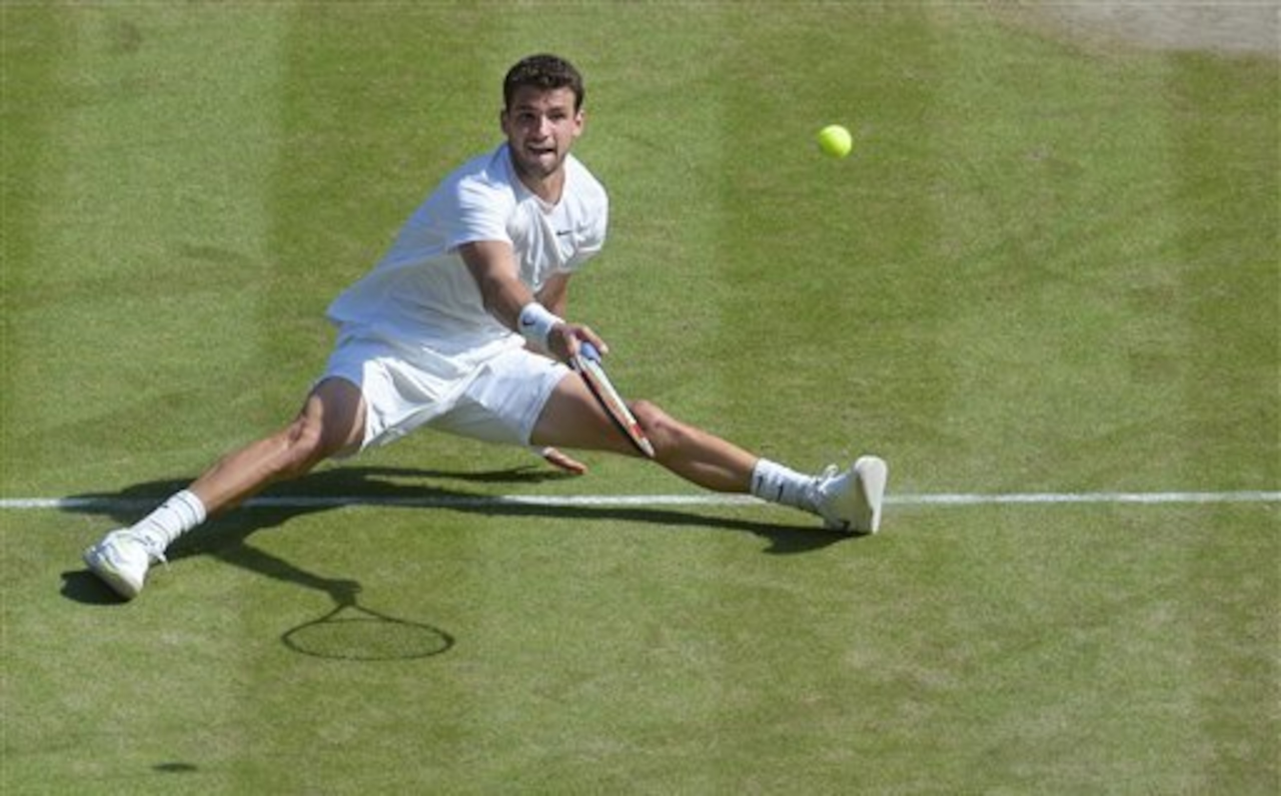 Grigor Dimitrov tries an acrobatic shot during the Wimbledon semifinal.