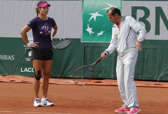 Li Na listens to former coach Carlos Rodriguez.