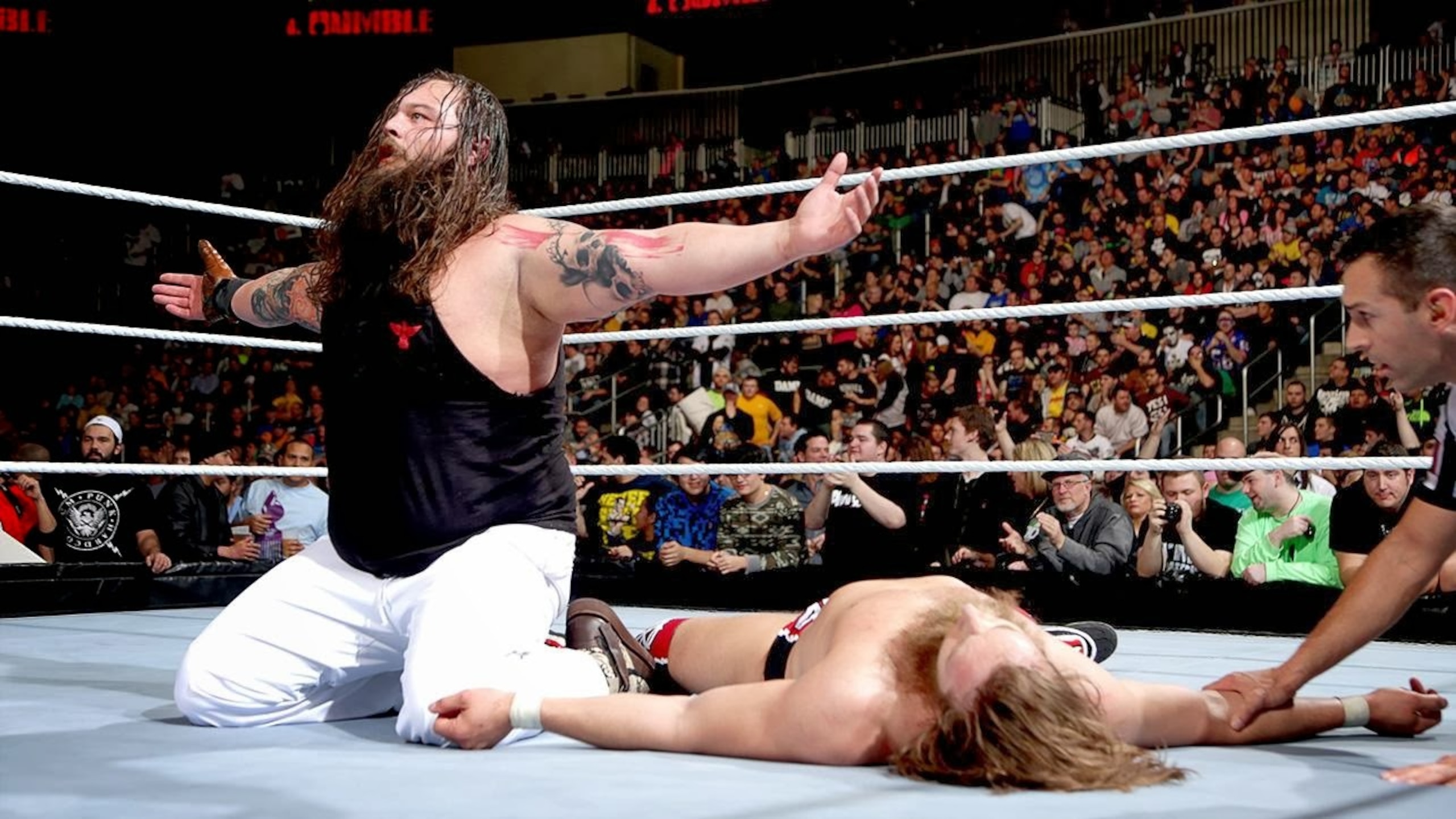 Bray Wyatt celebrates in front of a fallen Daniel Bryan.