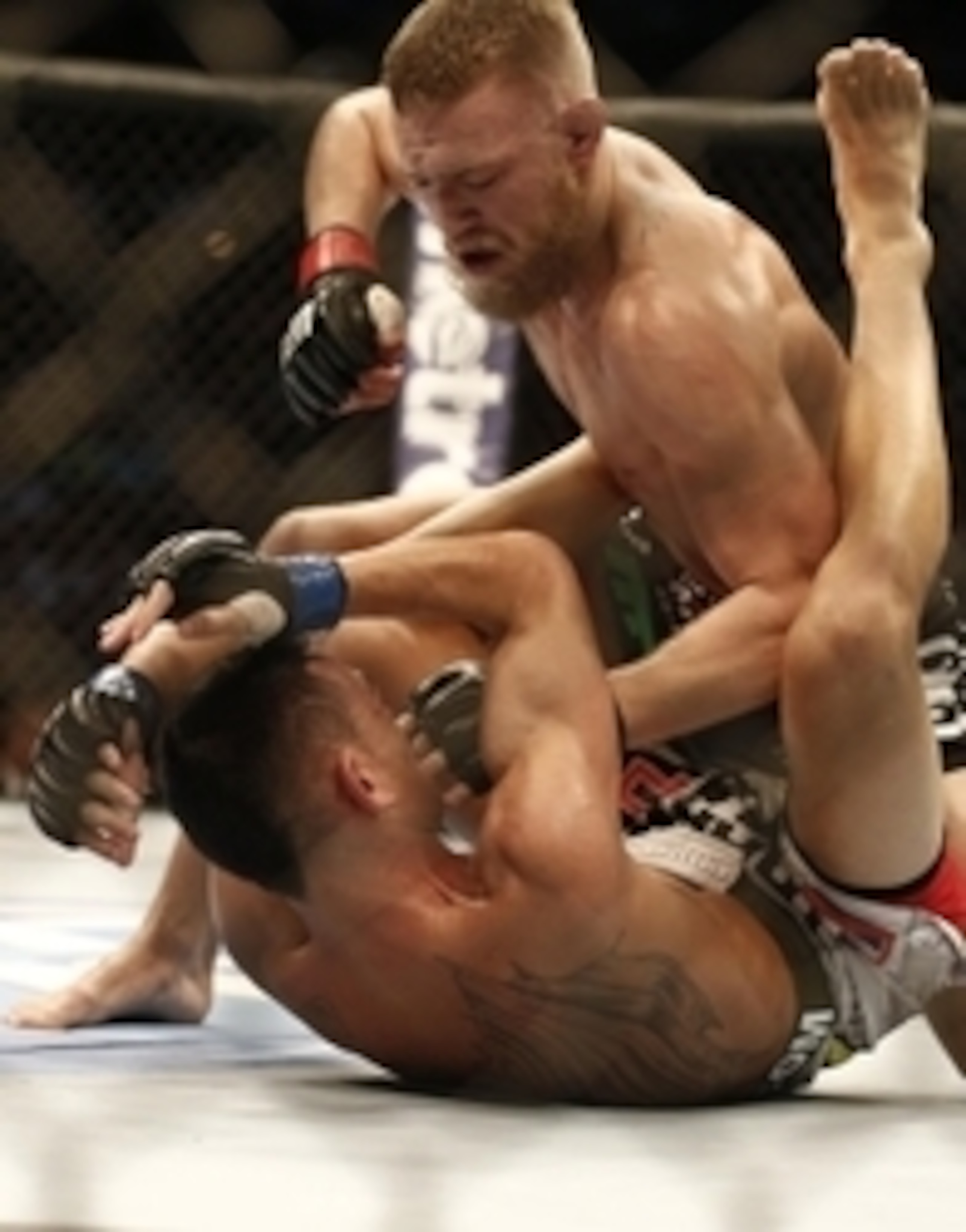 Conor McGregor (top) hammers Max Holloway