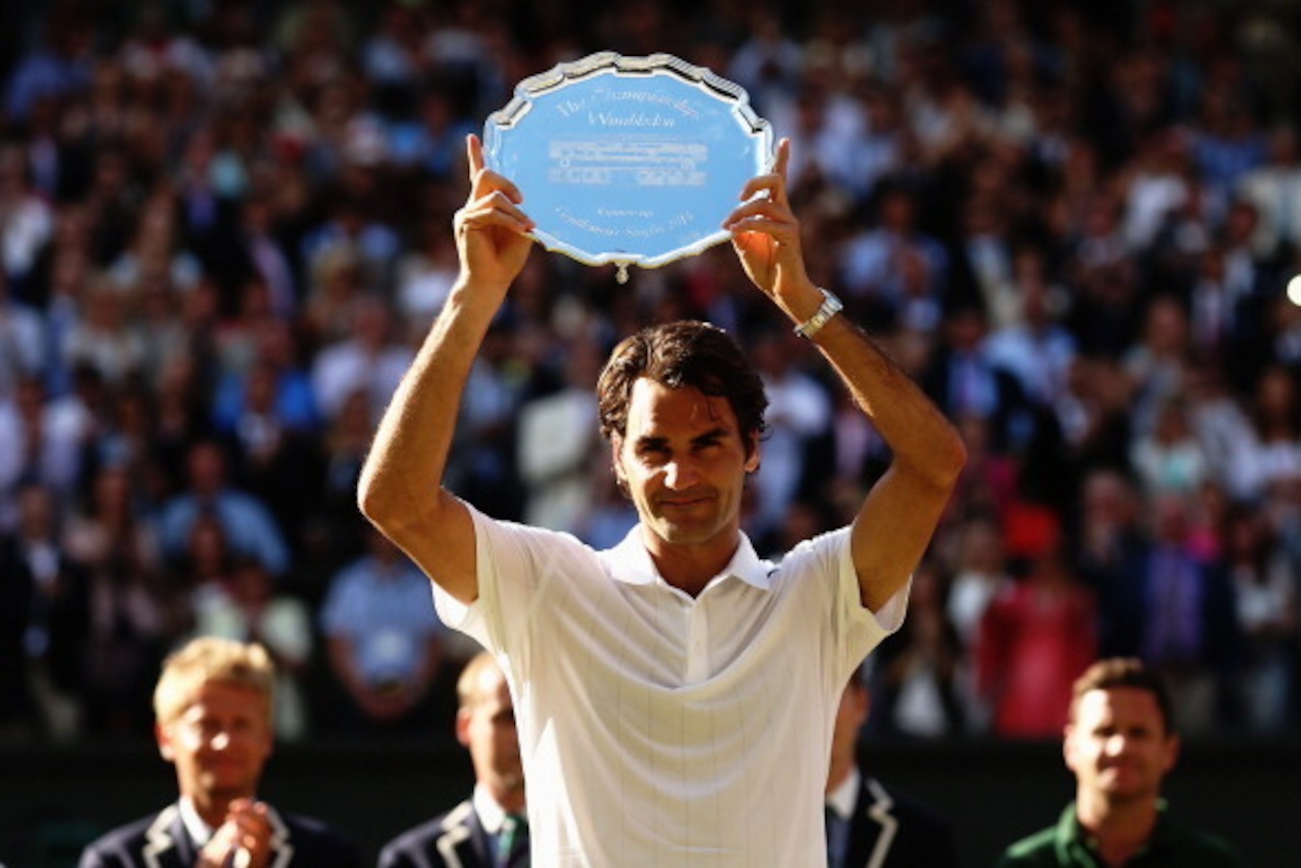 Roger Federer holds up the runner-up trophy at Wimbledon.