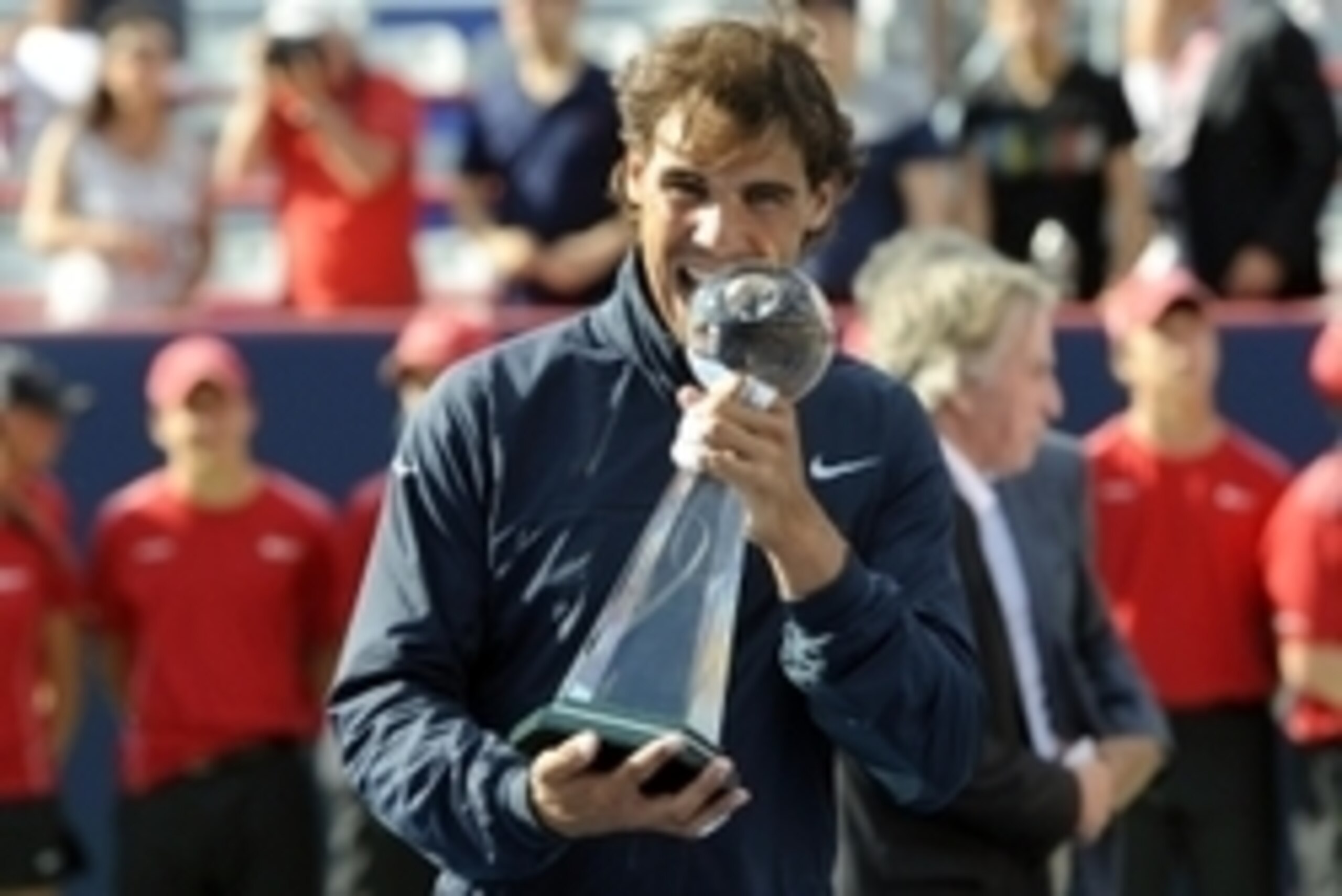 Rafael Nadal takes his traditional trophy bite after winning the 2013 Rogers Cup.