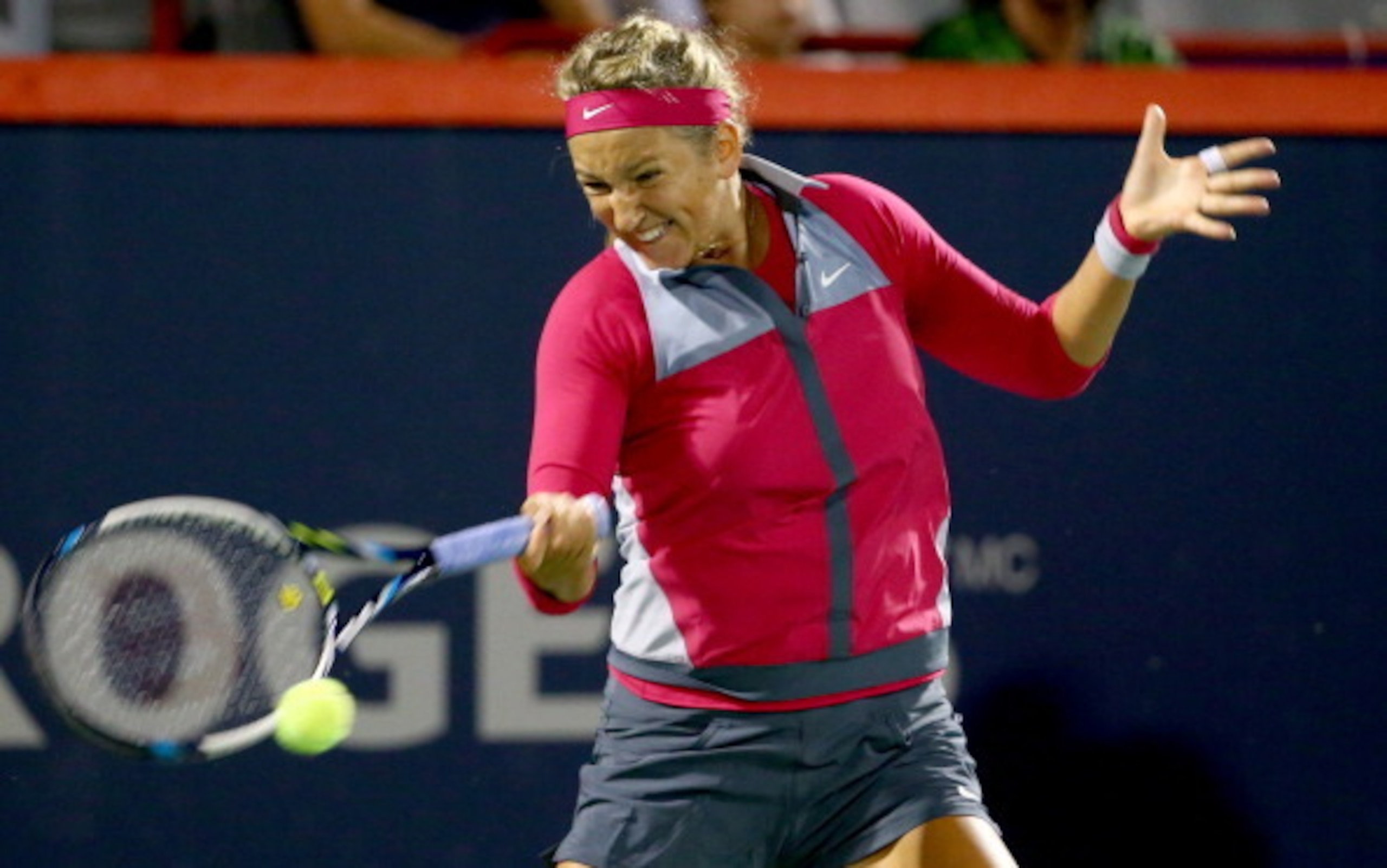 Victoria Azarenka readies to hit a forehand during an evening match at the 2014 Rogers Cup in Montreal.