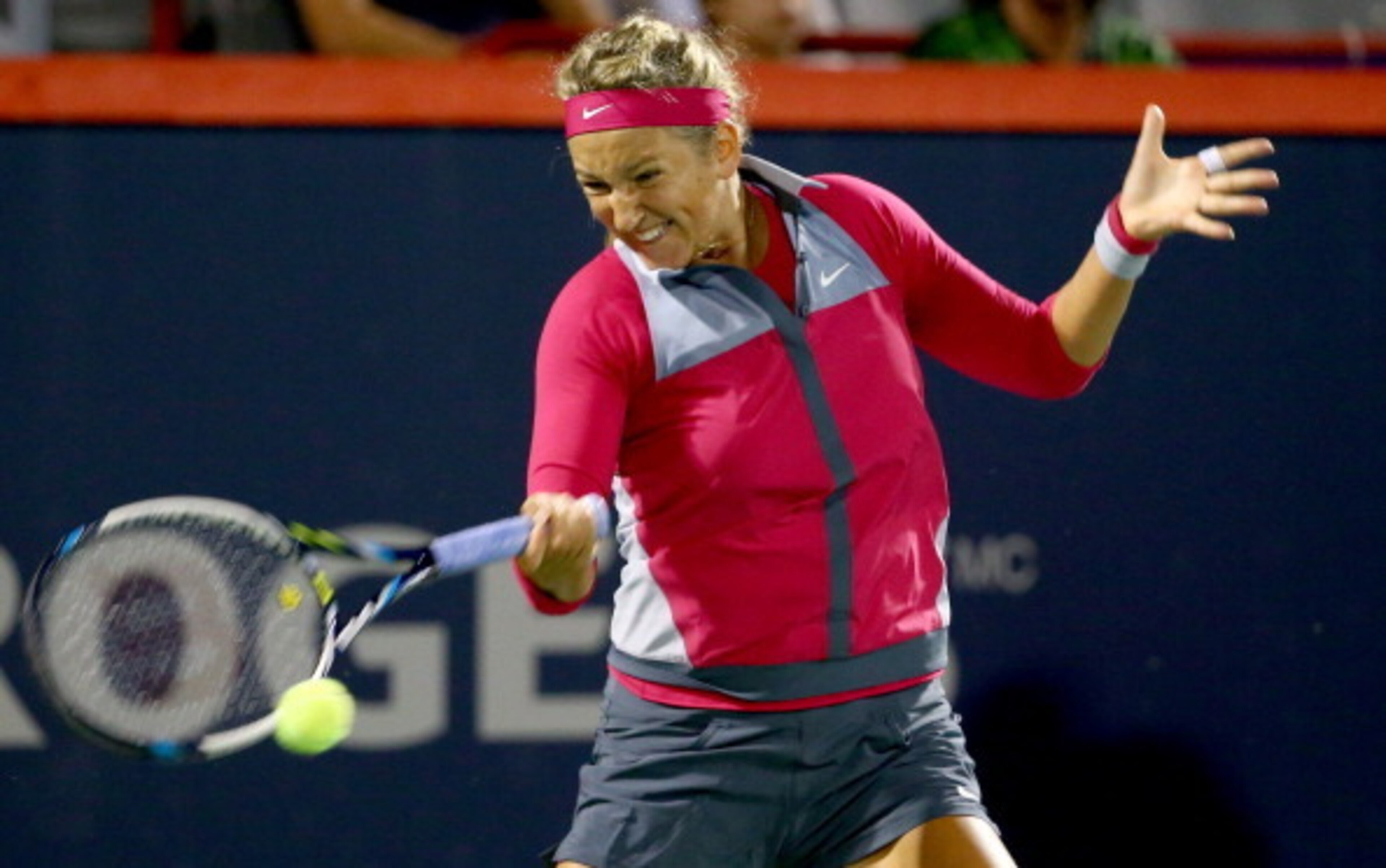 Victoria Azarenka readies to hit a forehand during an evening match at the 2014 Rogers Cup in Montreal.