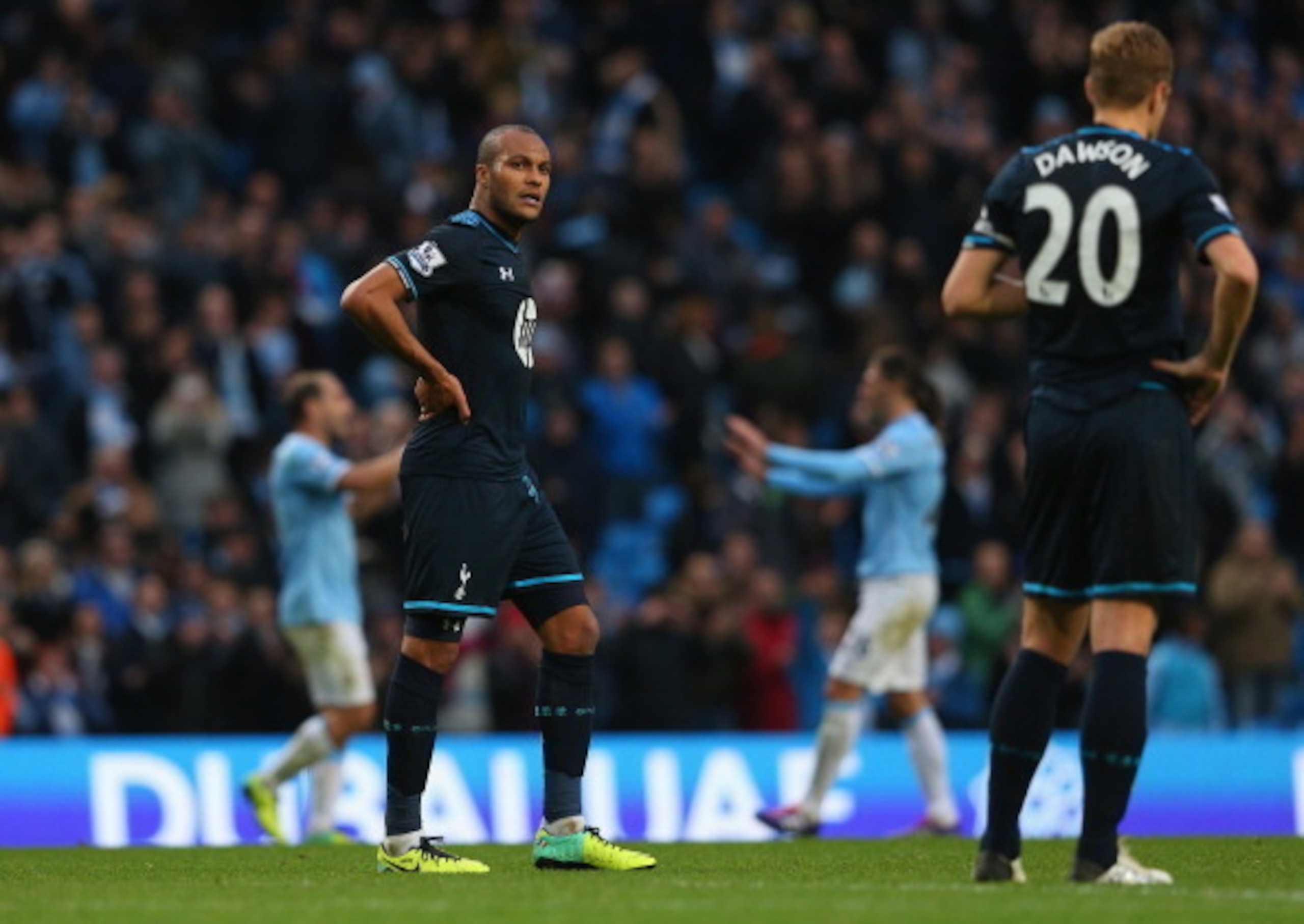 MANCHESTER, ENGLAND - NOVEMBER 24:  Younes Kaboul and Michael Dawson of Tottenham Hotspur look on dejected as Manchester City celebrate after the Barclays Premier League match between Manchester City and Tottenham Hotspur at Etihad Stadium on November 24,