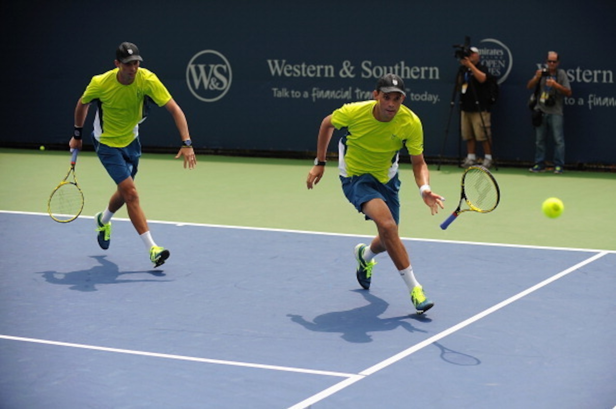One of the Bryan brothers  tosses his racket toward the ball during a doubles match in Cincinnati.