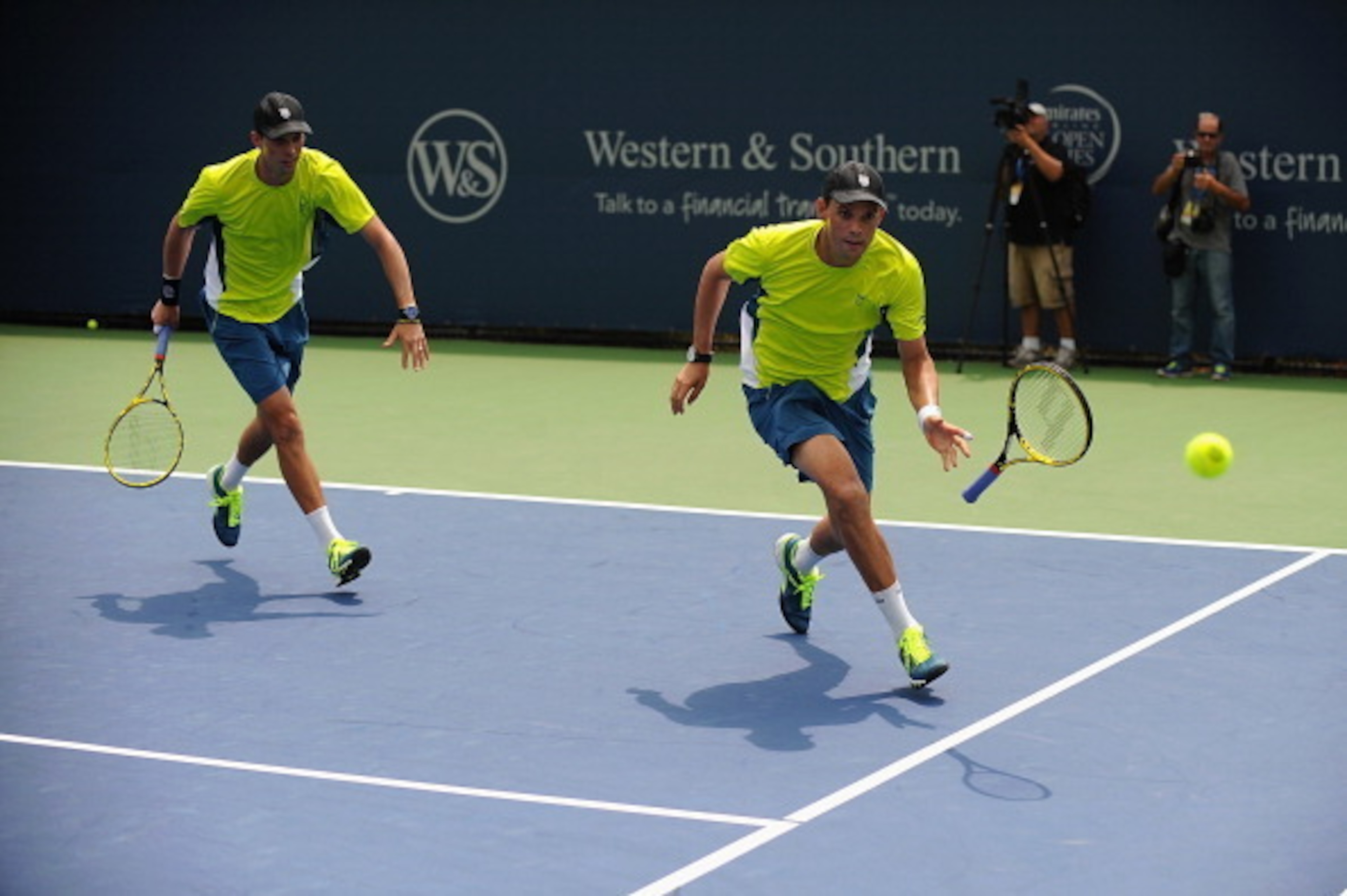 One of the Bryan brothers  tosses his racket toward the ball during a doubles match in Cincinnati.