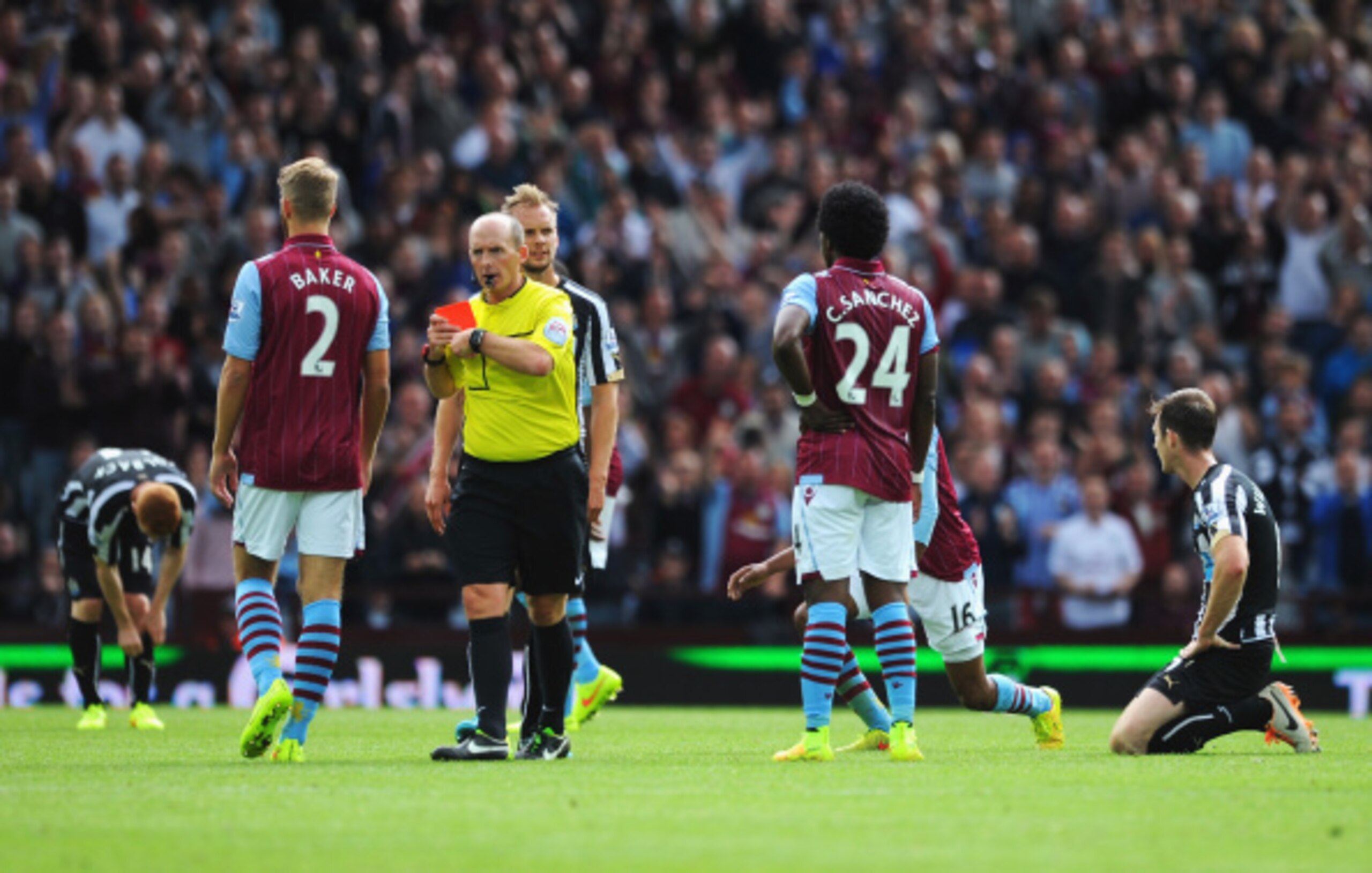 BIRMINGHAM, ENGLAND - AUGUST 23:  Referee Mike Dean turns away after showing the red card to Mike Williamson (R) of Newcastle United during the Barclays Premier League match between Aston Villa and Newcastle United at Villa Park on August 23, 2014 in Birm