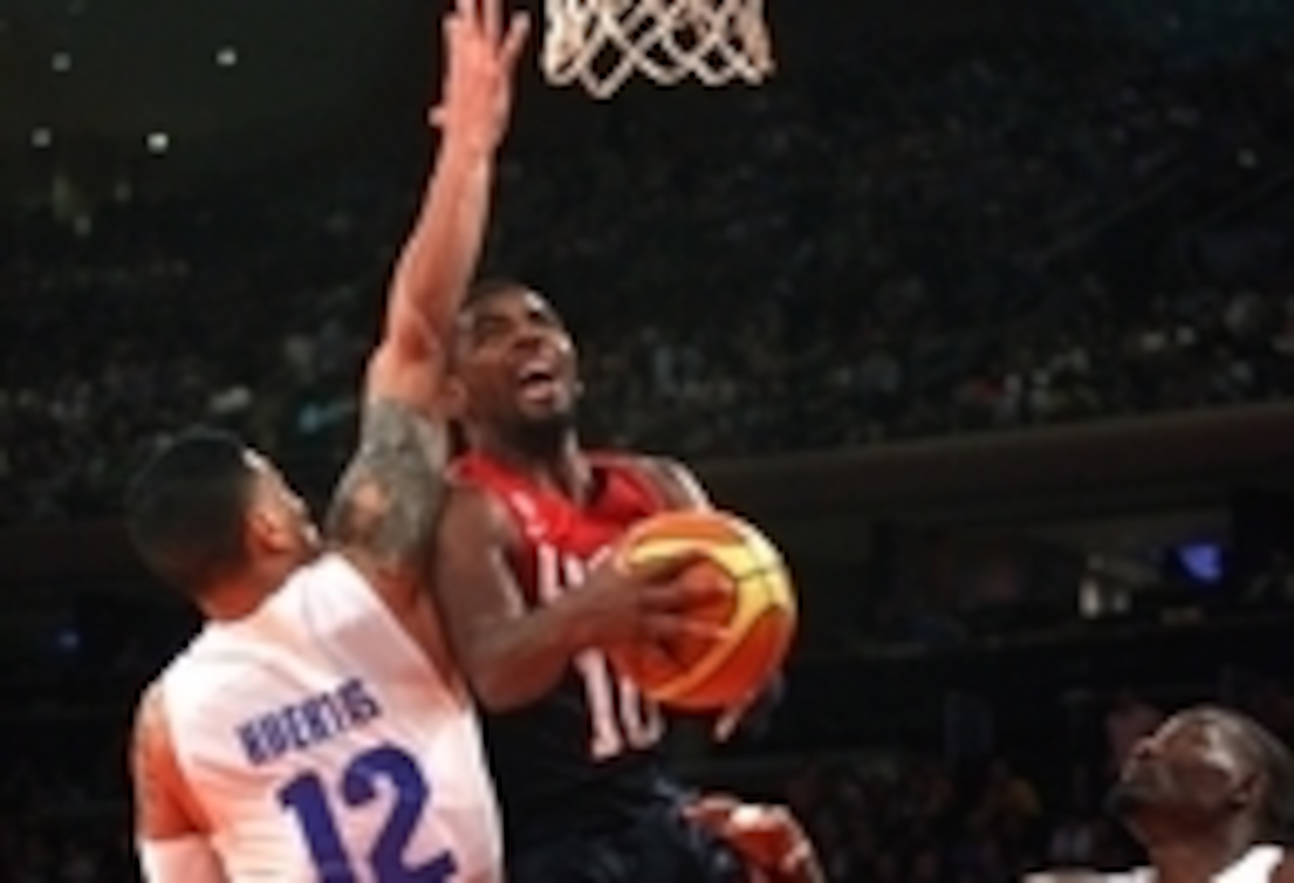 Aug 22, 2014; New York, NY, USA; United States guard Kyrie Irving (10) drives to the basket past Puerto Rico guard David Huertas (12) and center Ramon Clemente (4) during the second quarter of a game at Madison Square Garden. Mandatory Credit: Brad Penner