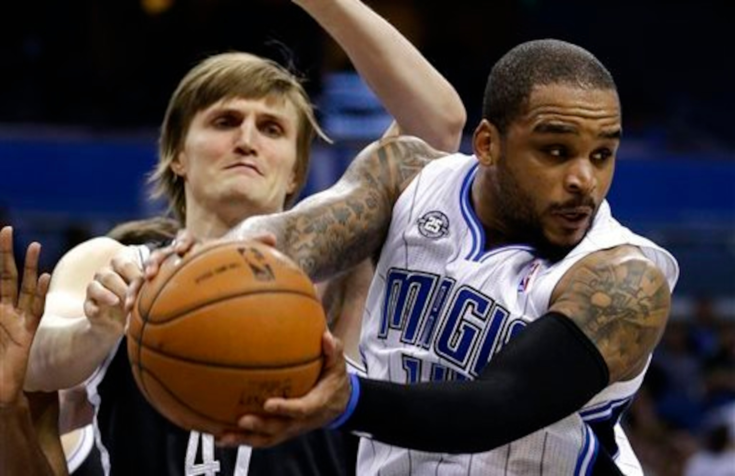 Orlando Magic's Jameer Nelson, right, looks to pass the ball as his path to the basket is blocked by Brooklyn Nets' Andrei Kirilenko, left, during the second half of an NBA basketball game in Orlando, Fla., Wednesday, April 9, 2014. Orlando won 115-111. (