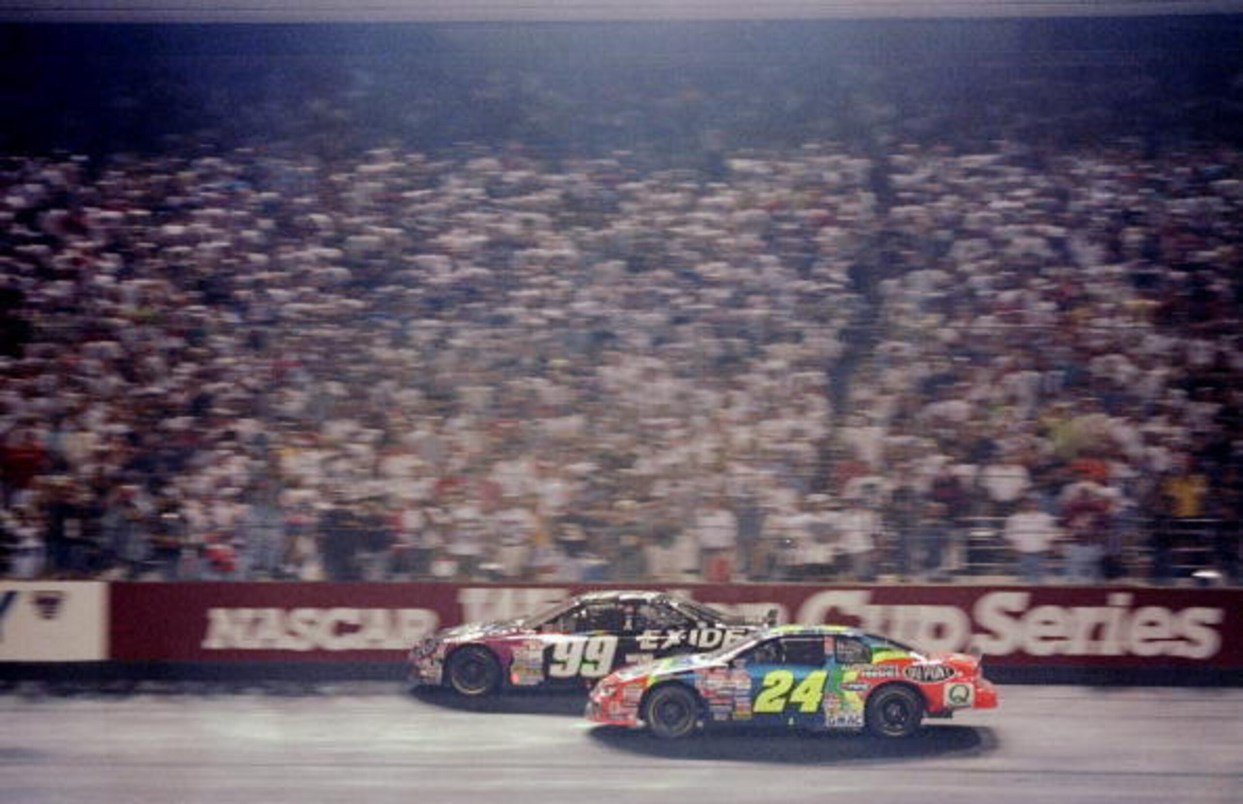 Action from 1998: Jeff Gordon (24) battles eventual race winner Jeff Burton (99).