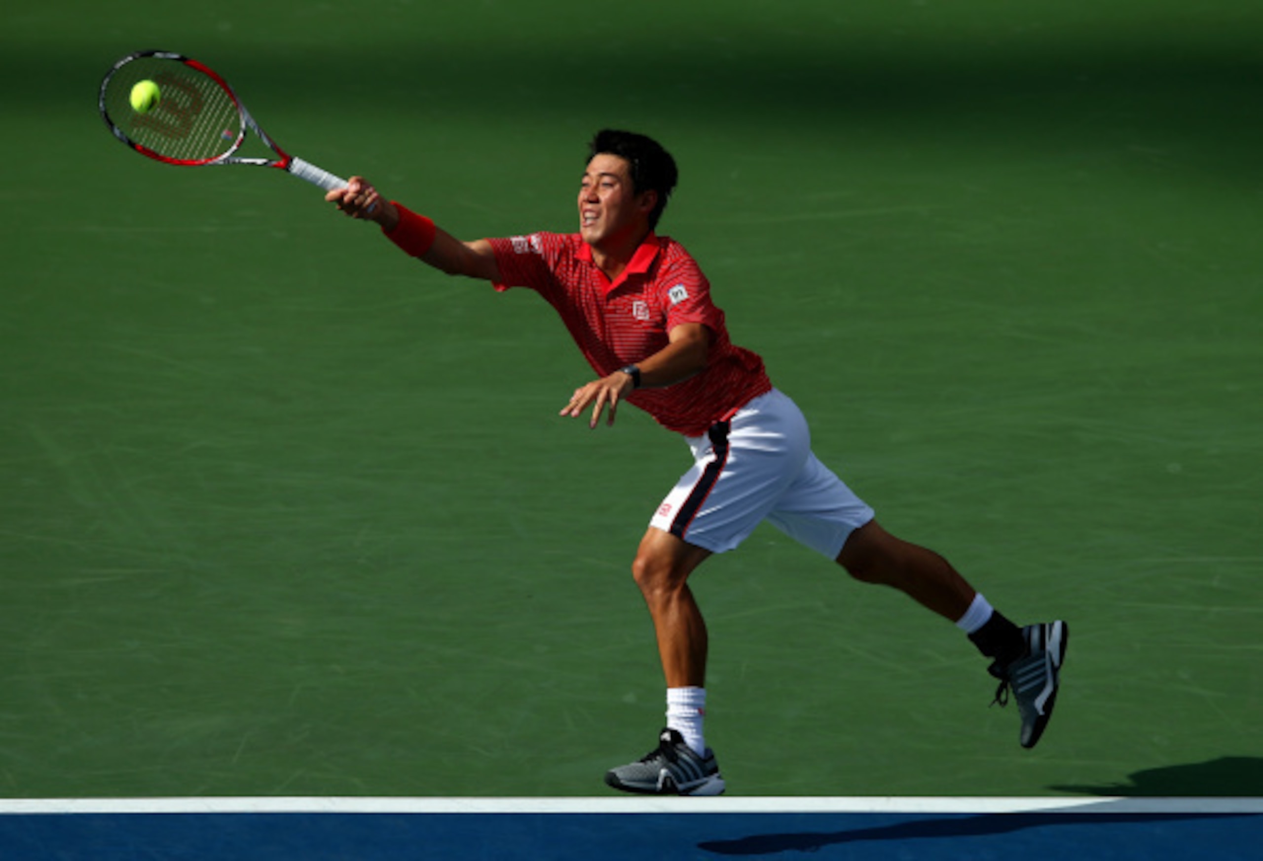 NEW YORK, NY - SEPTEMBER 03:  Kei Nishikori of Japan returns a shot against Stan Wawrinka of Switzerland during their men's singles quarterfinal match on Day Ten of the 2014 US Open at the USTA Billie Jean King National Tennis Center on September 3, 2014 