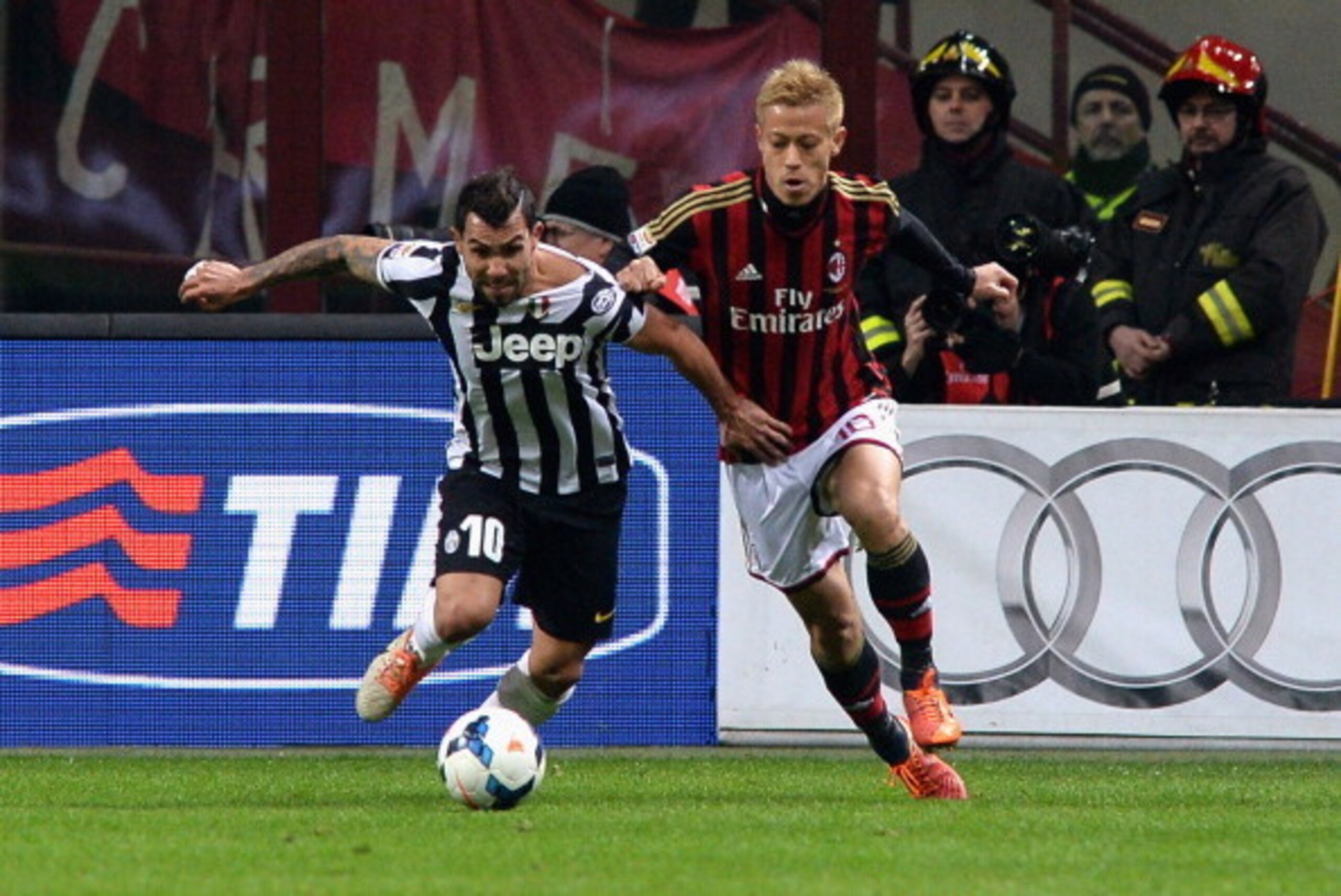 Carlos Tevez (left) and Keisuke Honda battled in last year's match between Juventus and Milan at San Siro.