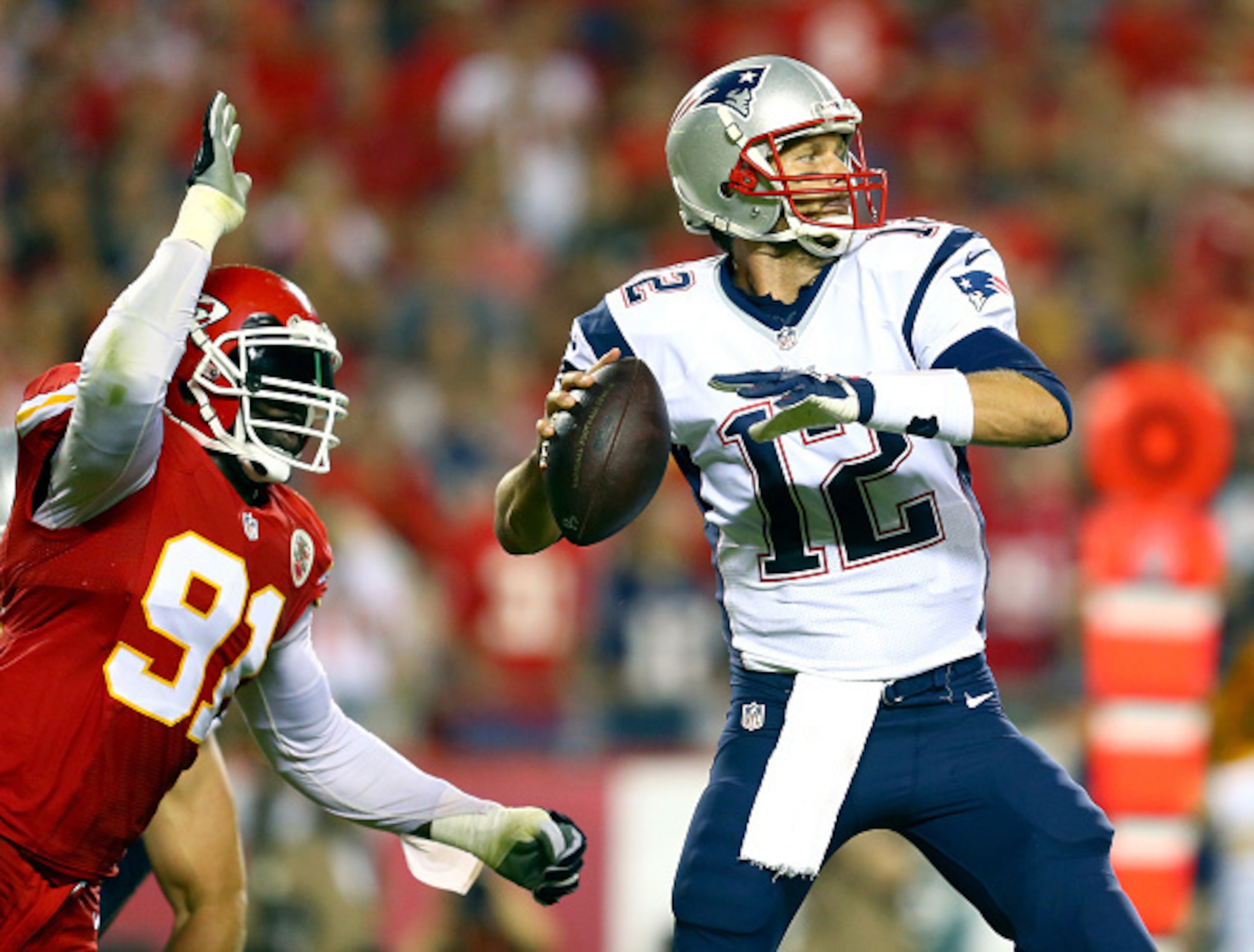 KANSAS CITY, MO - SEPTEMBER 29:  Tamba Hali #91 of the Kansas City Chiefs knocks the ball loose from Tom Brady #12 of the New England Patriots for a fumble during the third quarter at Arrowhead Stadium on September 29, 2014 in Kansas City, Missouri.  (Pho