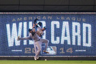 KANSAS CITY, MO - SEPTEMBER 30:  Jonny Gomes #15 and Sam Fuld #23 of the Oakland Athletics collide on a triple hit by Eric Hosmer #35 of the Kansas City Royals in the 12th inning during the American League Wild Card game at Kauffman Stadium on September 3