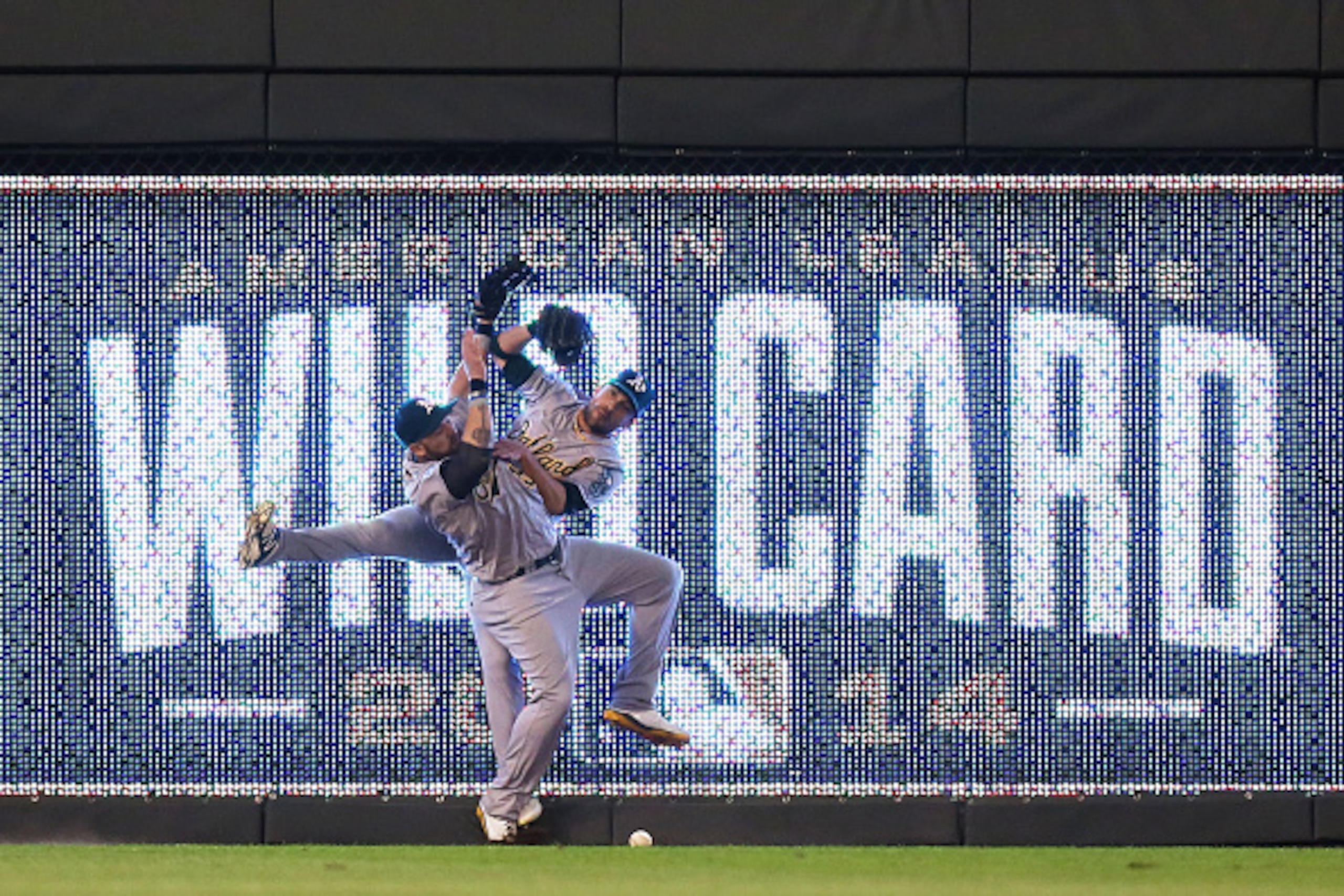 KANSAS CITY, MO - SEPTEMBER 30:  Jonny Gomes #15 and Sam Fuld #23 of the Oakland Athletics collide on a triple hit by Eric Hosmer #35 of the Kansas City Royals in the 12th inning during the American League Wild Card game at Kauffman Stadium on September 3