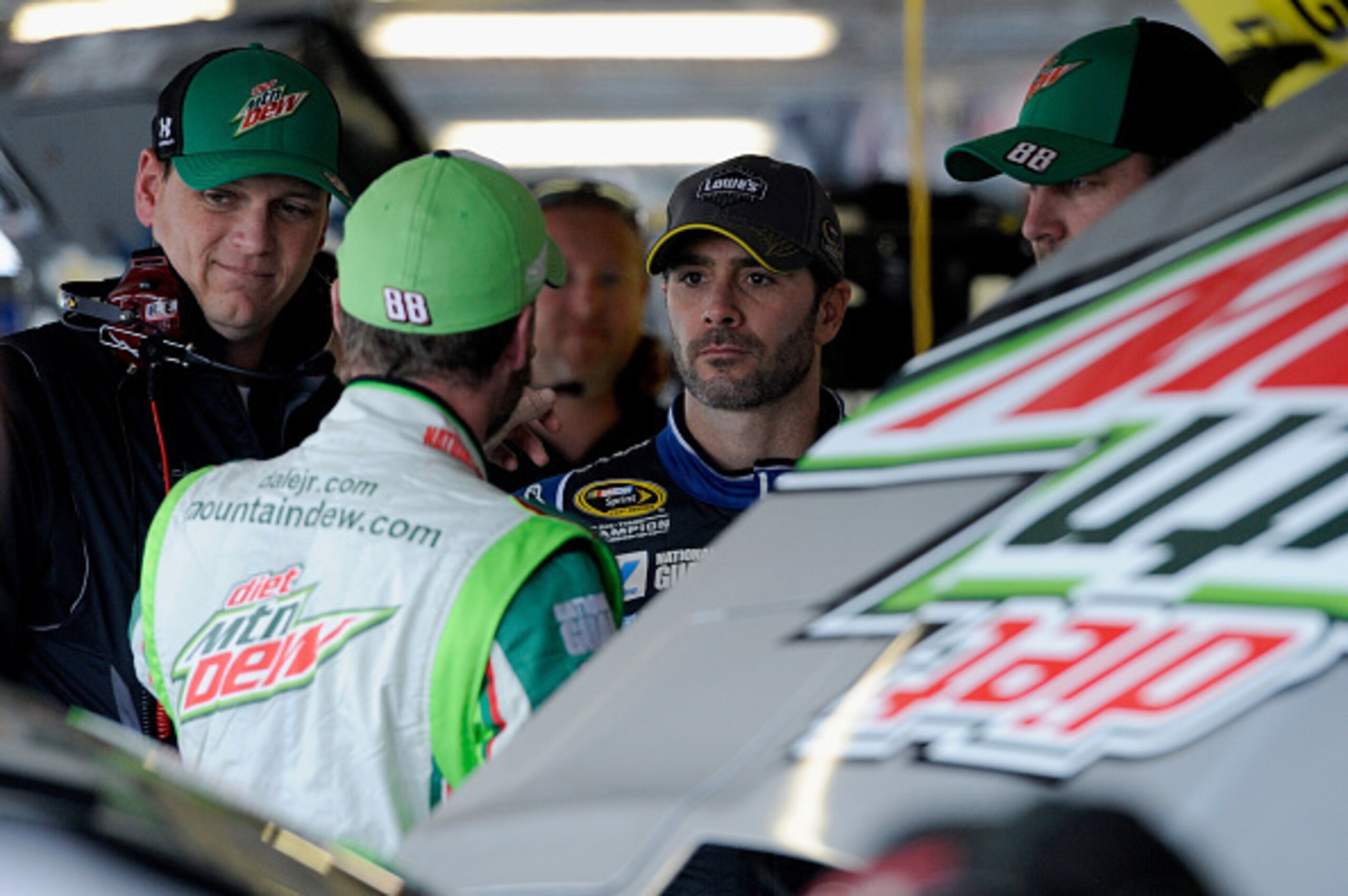 Dale Earnhardt Jr.'s crew chief (far left) talks with Earnhardt and Jimmie Johnson after both drivers encountered problems at Kansas.