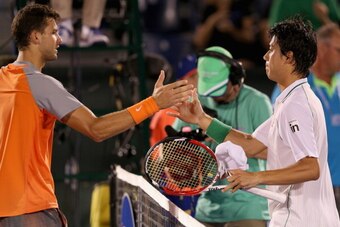 Grigor Dimitrov exchanges a handshake with Kei Nishikori at the net at the 2014 Sony Open.