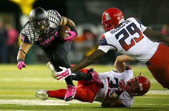 EUGENE, OR - OCTOBER 02:  Thomas Tyner #24 of the Oregon Ducks is tripped up by Scooby Wright III #33 and Jarvis McCall Jr. #29 of the Arizona Wildcats at Autzen Stadium on October 2, 2014  in Eugene, Oregon.  (Photo by Jonathan Ferrey/Getty Images)