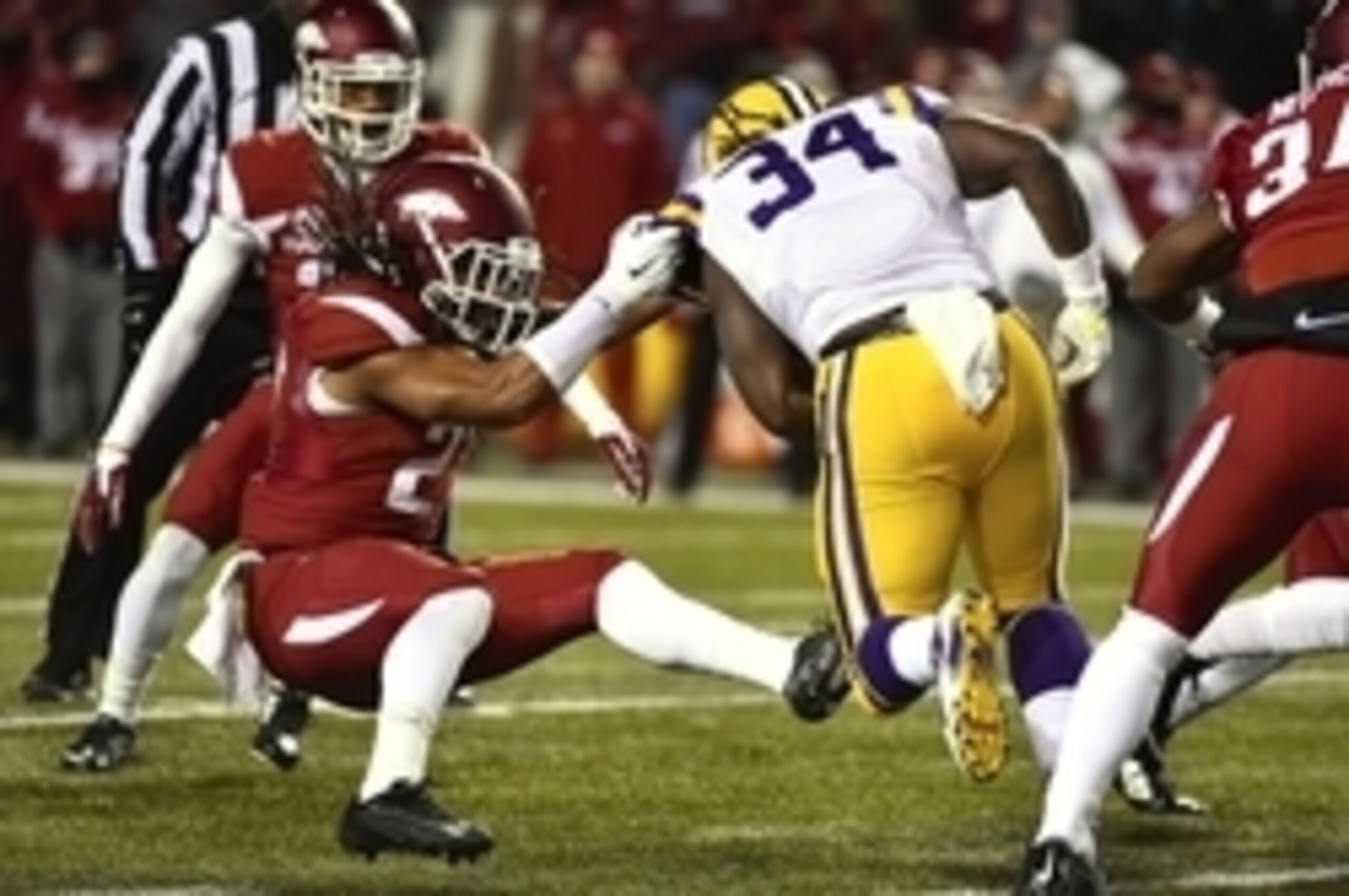 LSU running back Darrel Williams (No. 34) runs through an Arkansas tackler.
