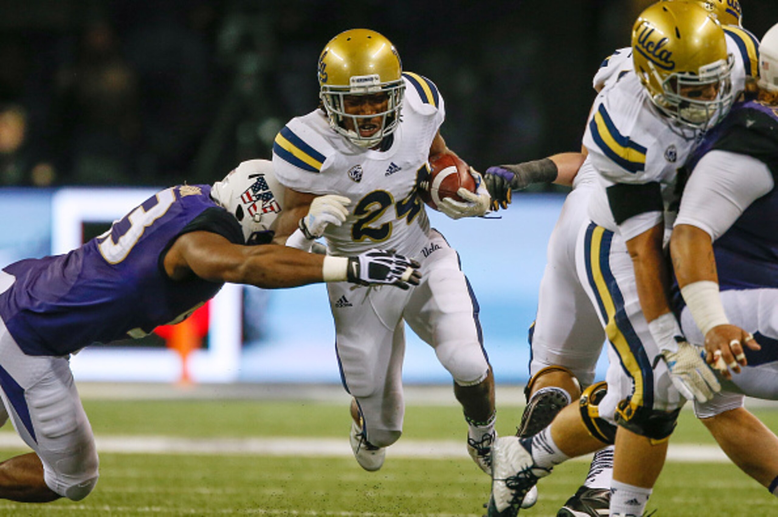 SEATTLE, WA - NOVEMBER 08:  Running back Paul Perkins #24 of the UCLA Bruins rushes against the Washington Huskies on November 8, 2014 at Husky Stadium in Seattle, Washington.  (Photo by Otto Greule Jr/Getty Images)