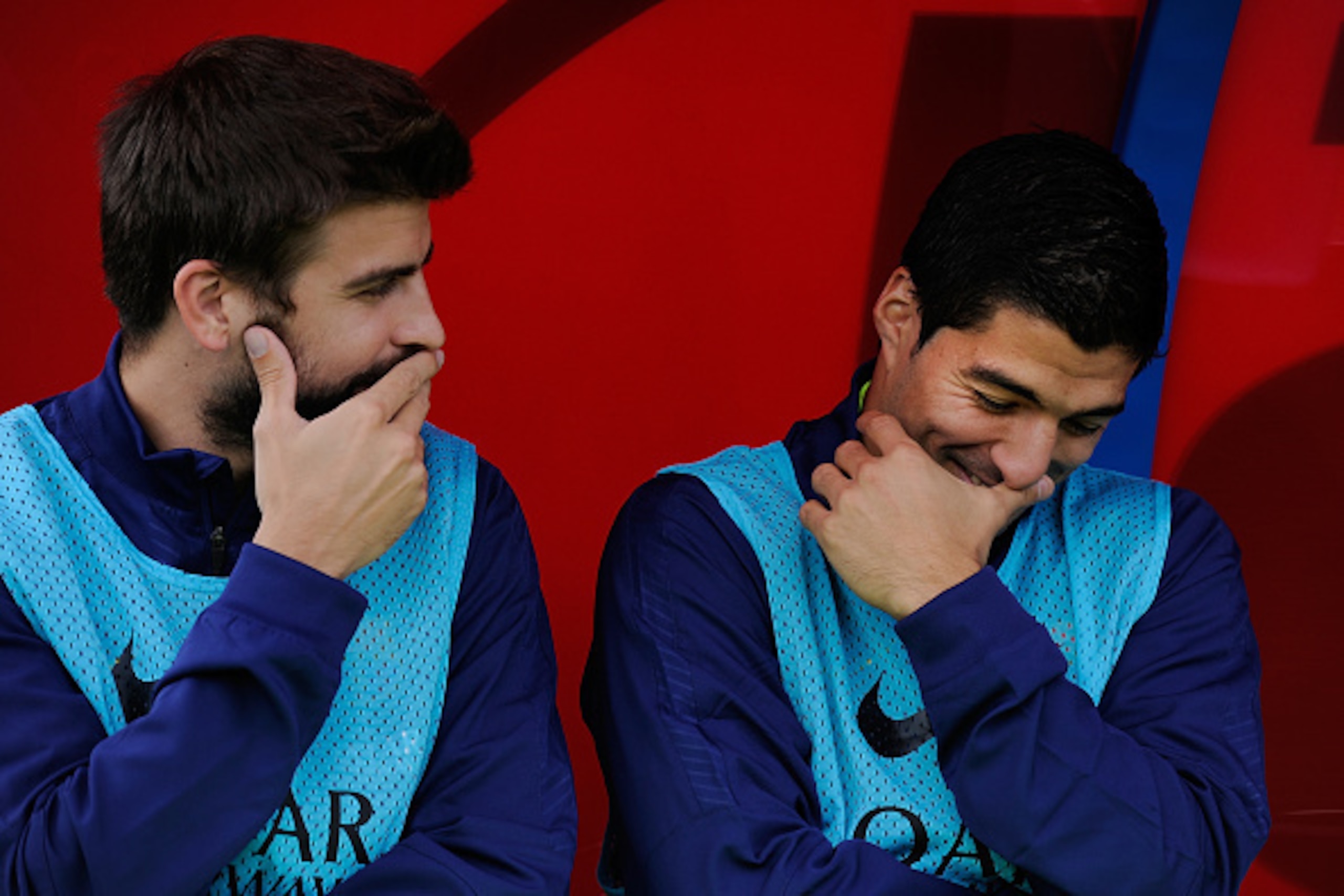 ALMERIA, SPAIN - NOVEMBER 08: Gerard Pique of FC Barcelona chats with team-mate Luis Suarez on the substitutes bench during the La Liga match between UD Almeria and FC Barcelona at estadio de los Juegos Mediterraneos on November 8, 2014 in Almeria, Spain.