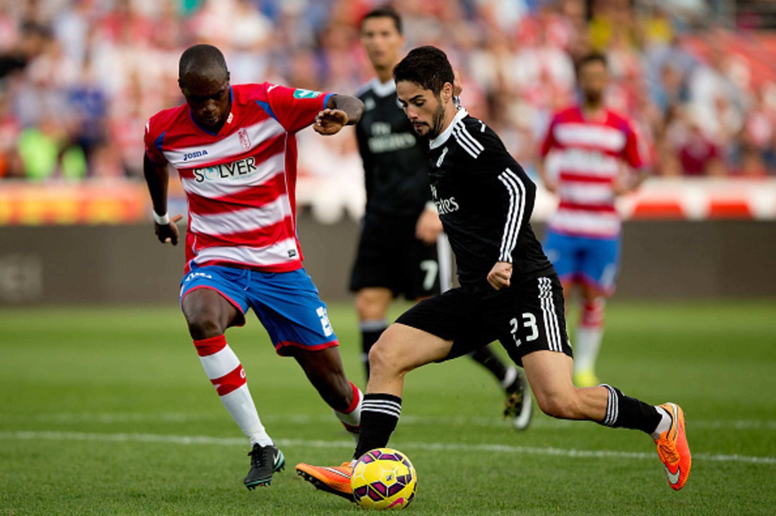 GRANADA, SPAIN - NOVEMBER 01:  Francisco Roman Alarcon alias Isco (R) of Real Madrid CF competes for the ball with Allan Nyom (L) of Granada CF during the La Liga match between Granada CF and Real Madrid CF at Nuevo Estadio de Los Carmenes on November 1, 