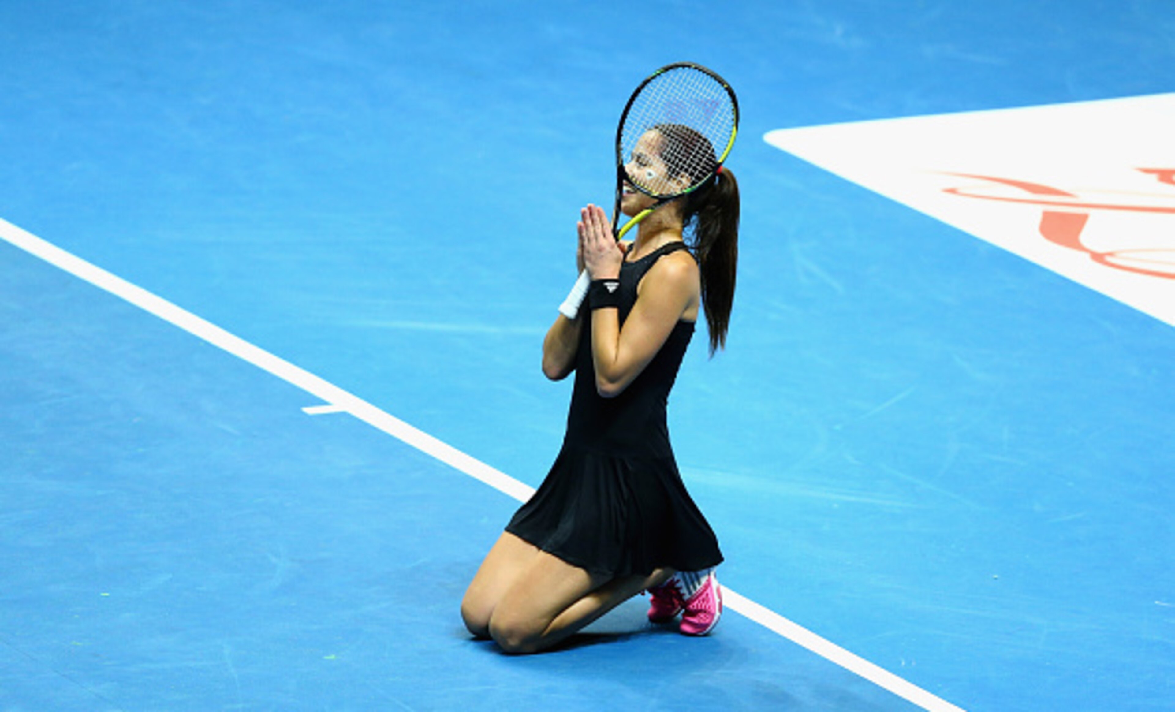 Ana Ivanovic kneels in prayer as she awaits the result of a challenge.