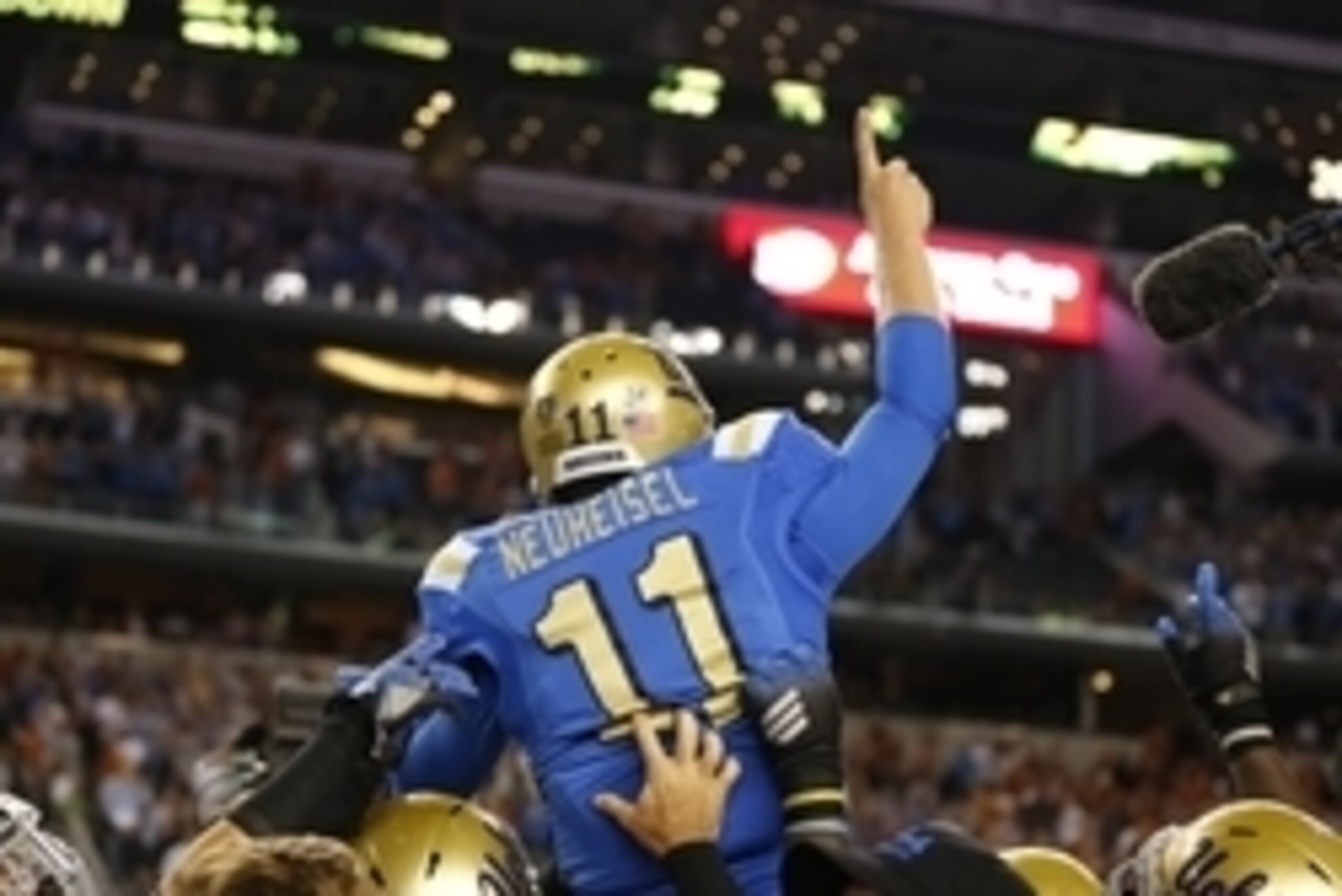 Neuheisel being carried off the field by his teammates in Texas.