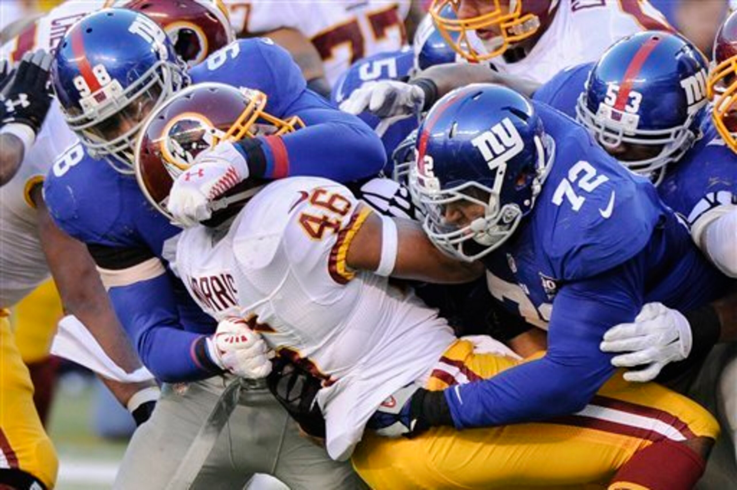 The Giants gang-tackle Redskins RB Alfred Morris.