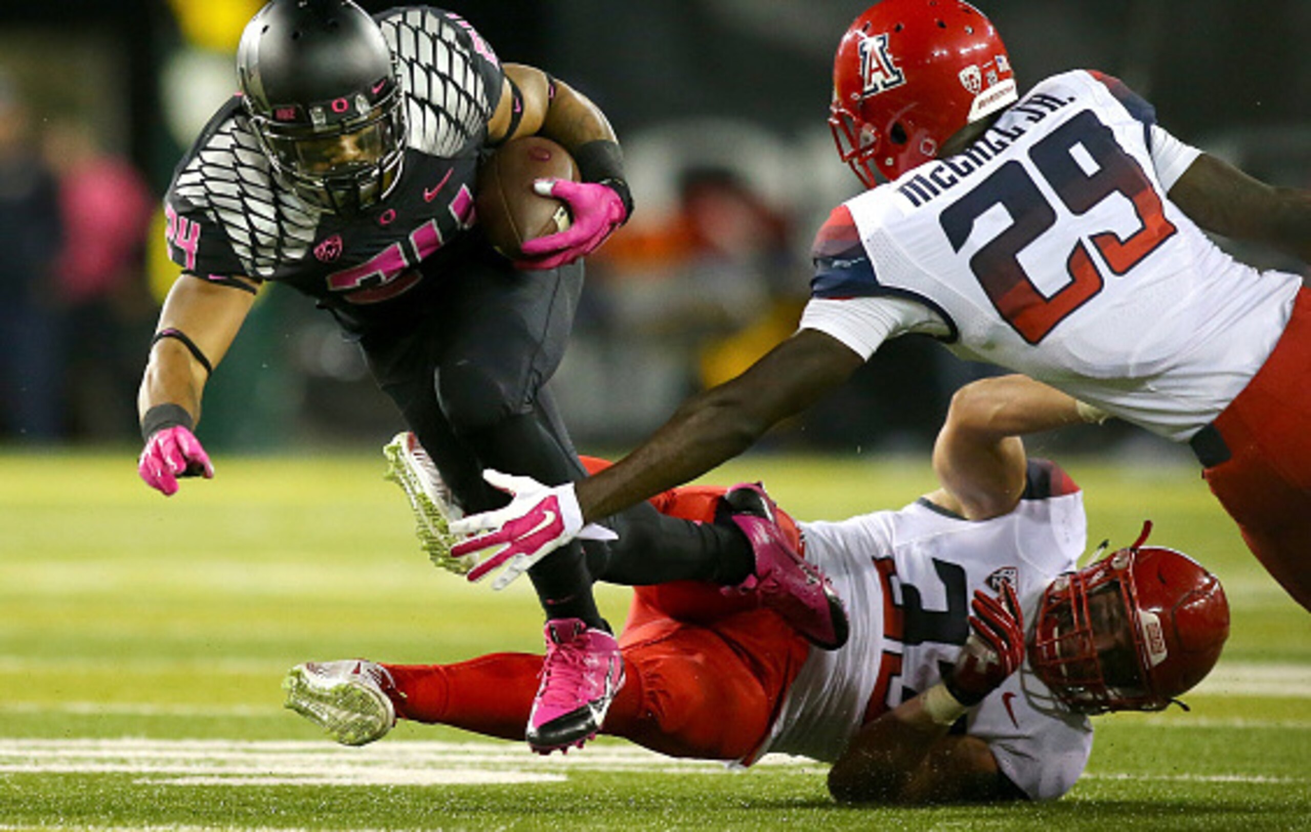 EUGENE, OR - OCTOBER 02:  Thomas Tyner #24 of the Oregon Ducks is tripped up by Scooby Wright III #33 and Jarvis McCall Jr. #29 of the Arizona Wildcats at Autzen Stadium on October 2, 2014  in Eugene, Oregon.  (Photo by Jonathan Ferrey/Getty Images)