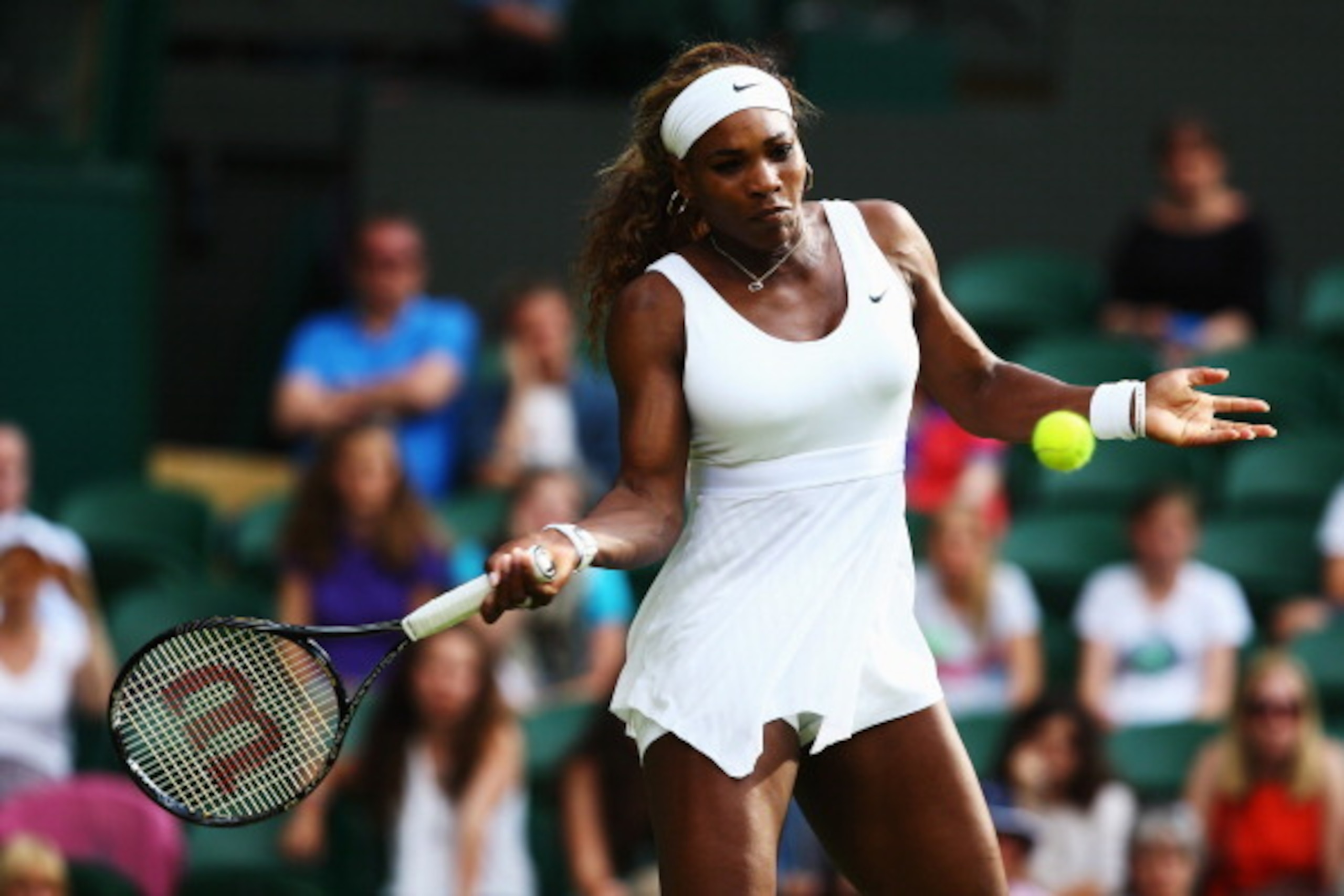 Serena Williams hits a forehand during a match at 2014 Wimbledon championships.