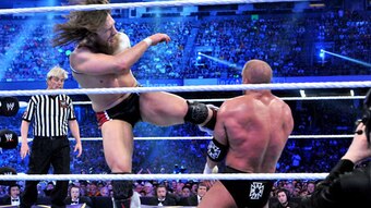 Daniel Bryan kicks the chest of Triple H.