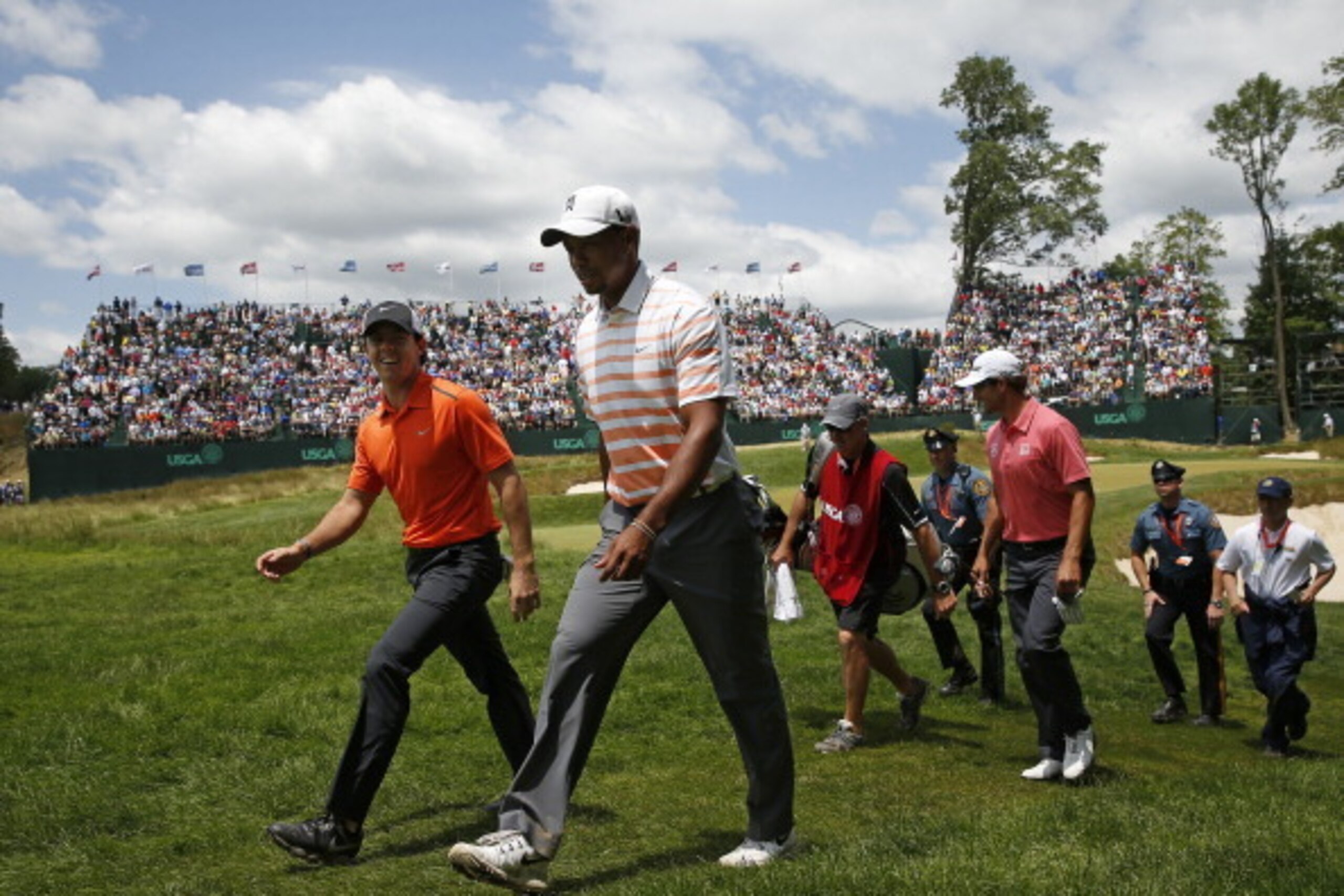 Tiger Woods and Rory McIlroy lead a procession down the fairway.