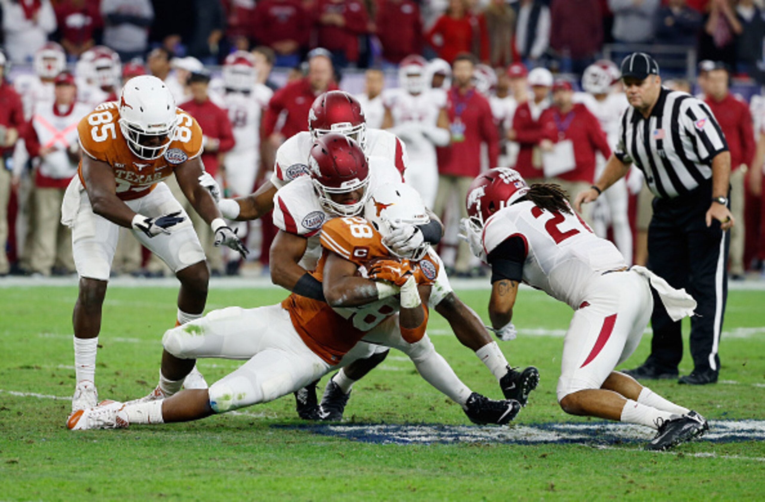HOUSTON, TX - DECEMBER 29:  Braylon Mitchell #34 of the Arkansas Razorbacks tackles Malcolm Brown #28 of the Texas Longhorns in the first half of their game at the AdvoCare V100 Texas Bowl at NRG Stadium on December 29, 2014 in Houston, Texas.  (Photo by 