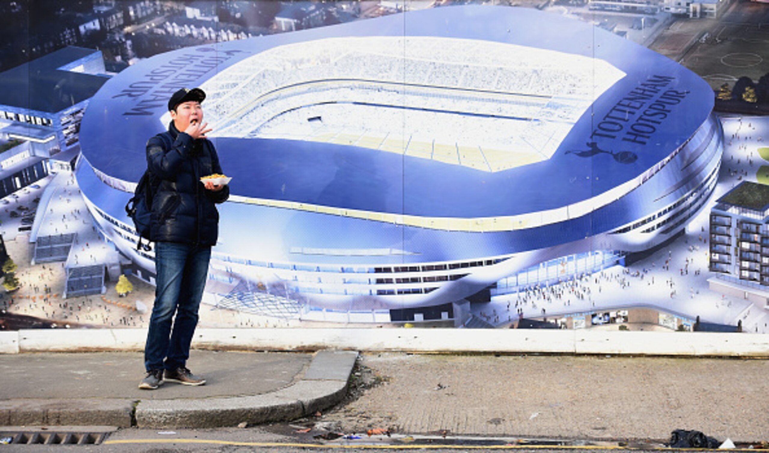 LONDON, ENGLAND - DECEMBER 20: A fan eats outside the ground prior to the Barclays Premier League match between Tottenham Hotspur and Burnley at White Hart Lane on December 20, 2014 in London, England.  (Photo by Laurence Griffiths/Getty Images)